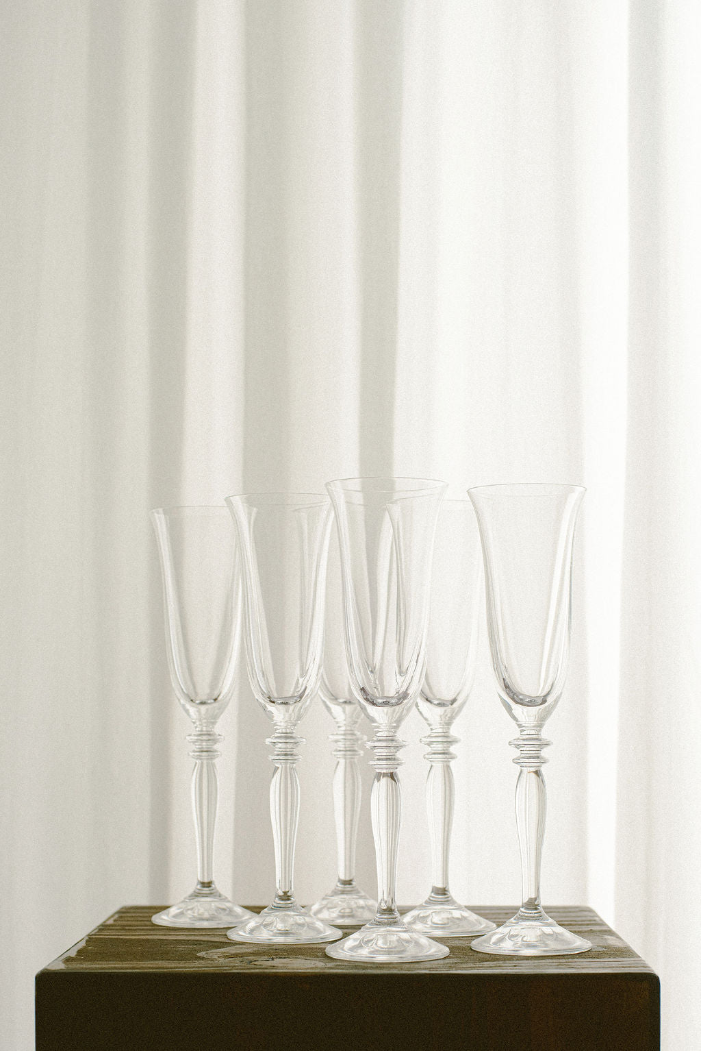 Vintage Champagne Flutes — close-up of clear glass flutes on wood