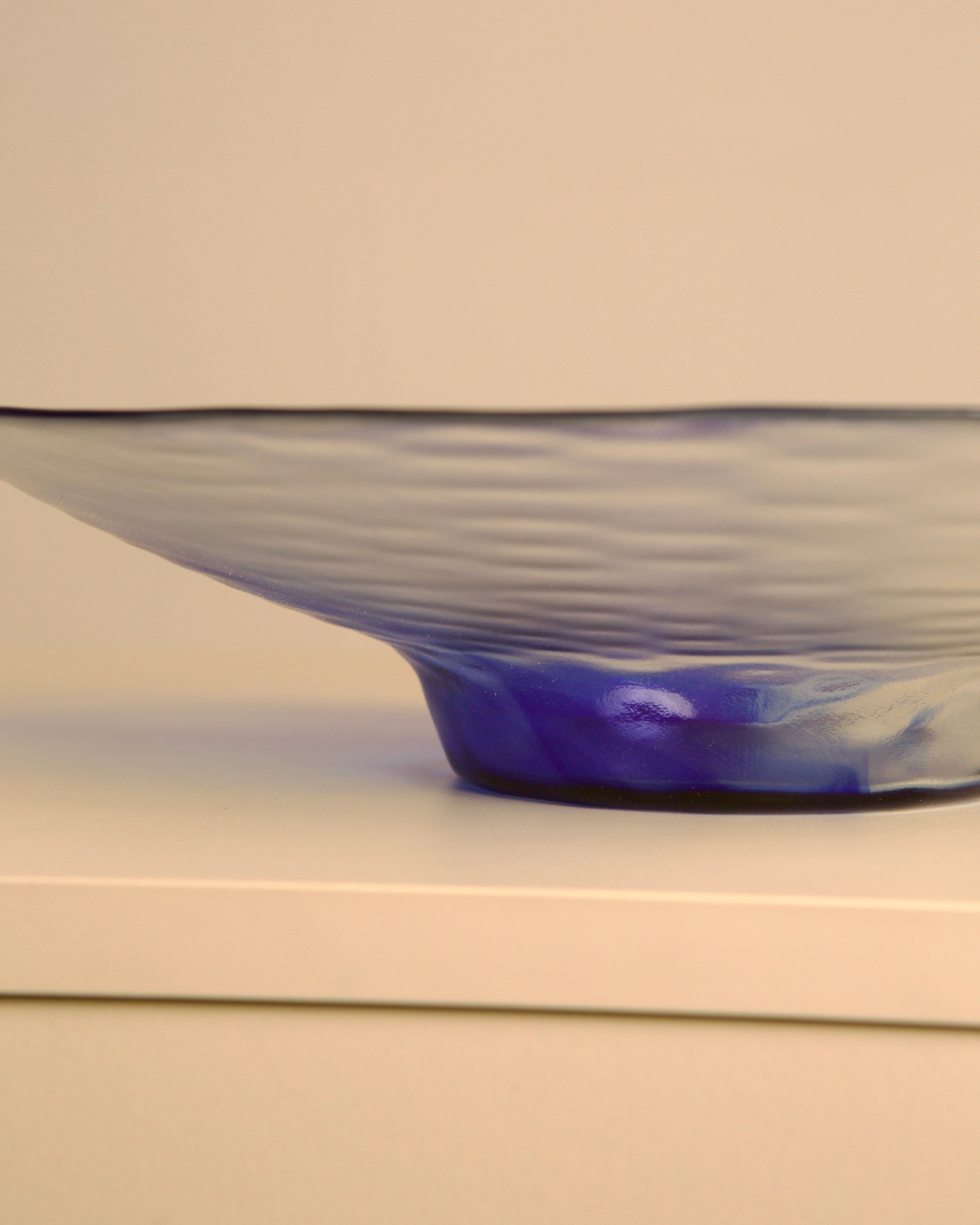 Large 80s Italian circular dish in transparent and blue wavy glass — side angle