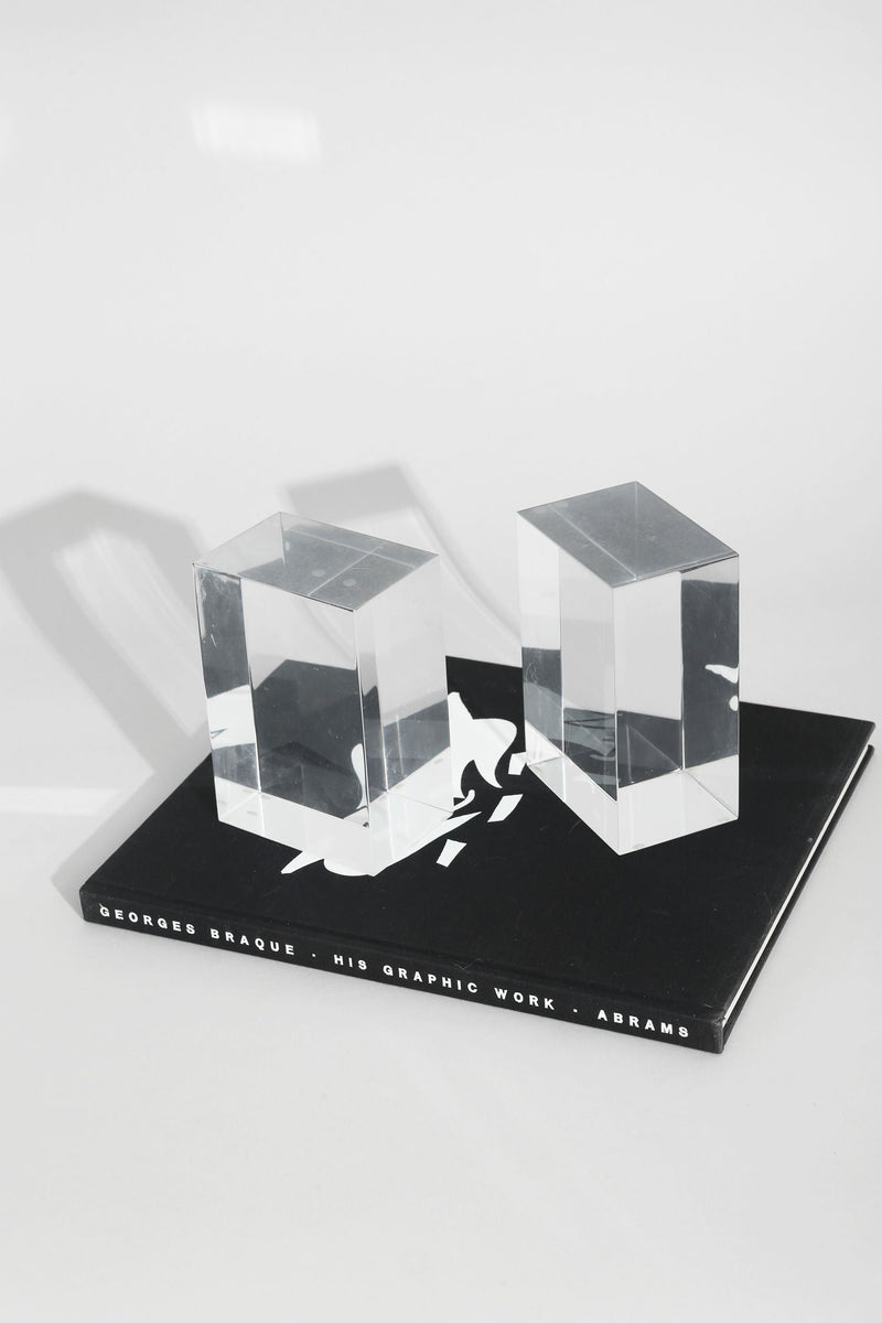 Clear acrylic cube bookends on black base displaying Georges Braque book