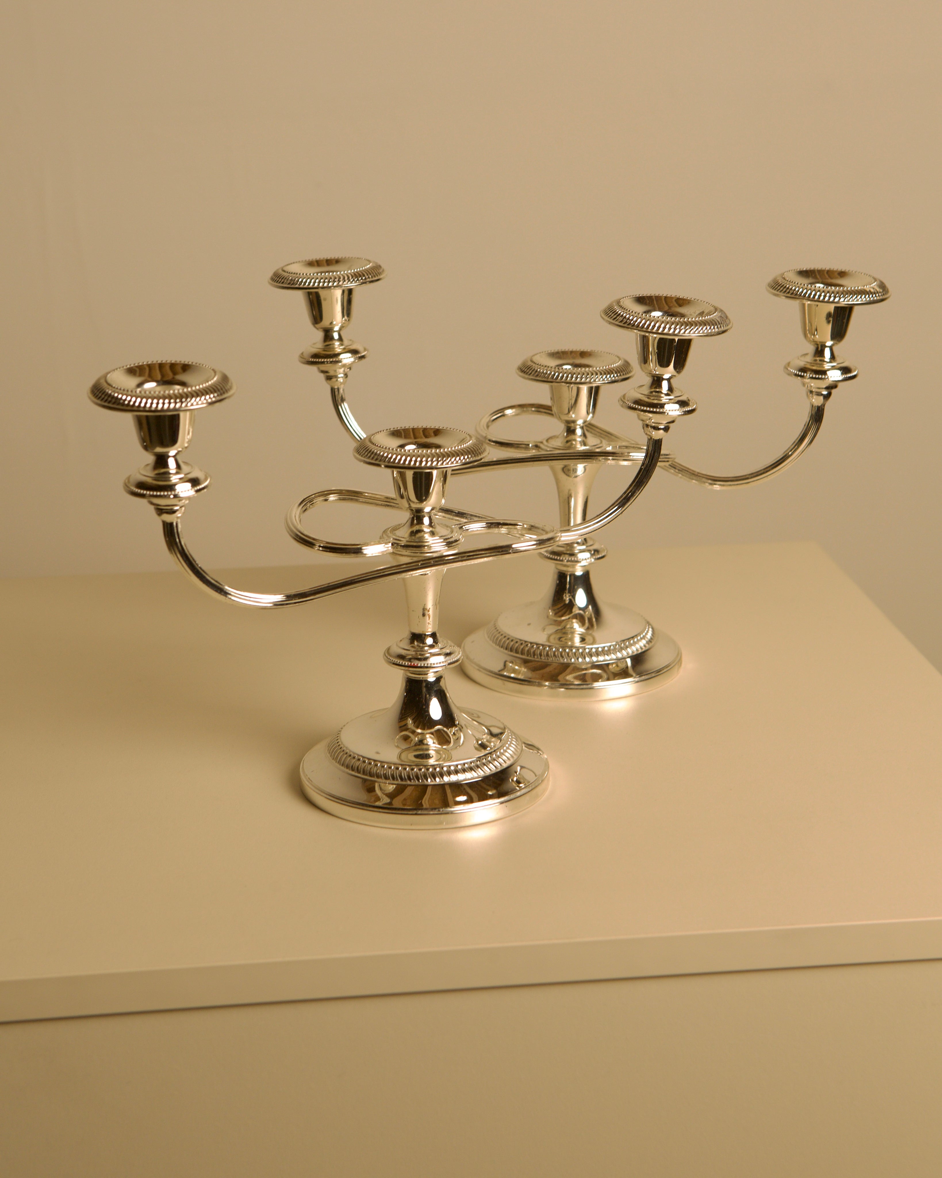 Pair of Italian metal "Medusa" candlesticks, 1980s — side view on neutral background