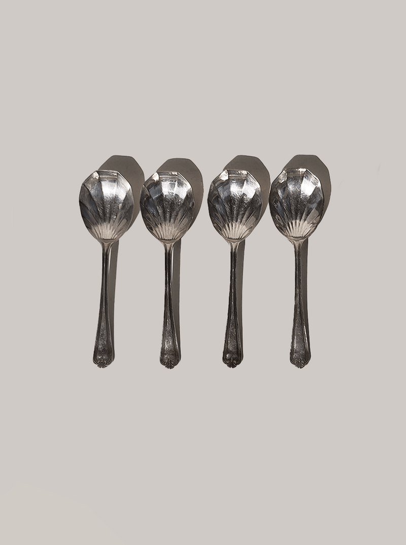 Four silver-plated dessert spoons with decorative shell bowls