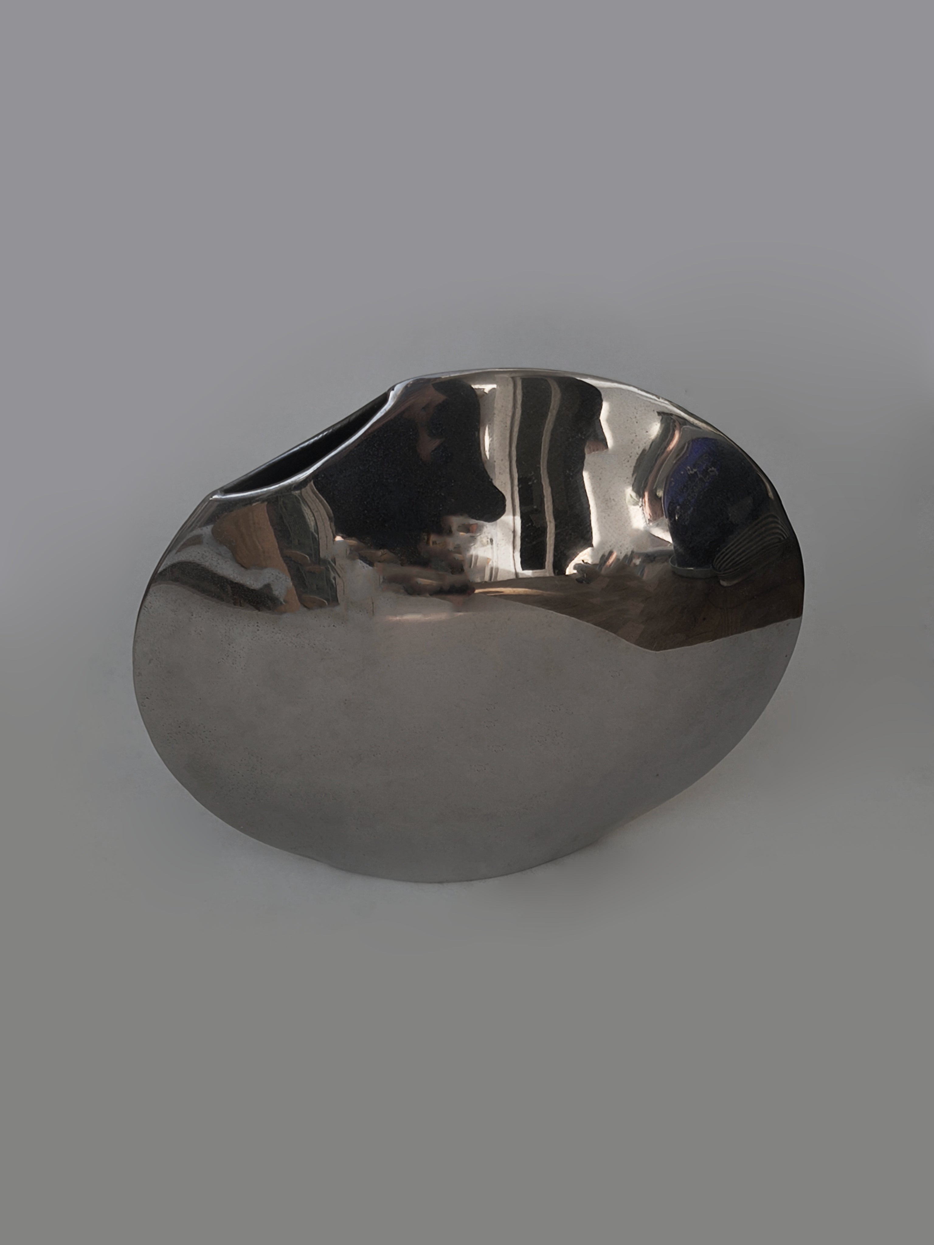 Pair of Round Vases — side angle of polished metal surface