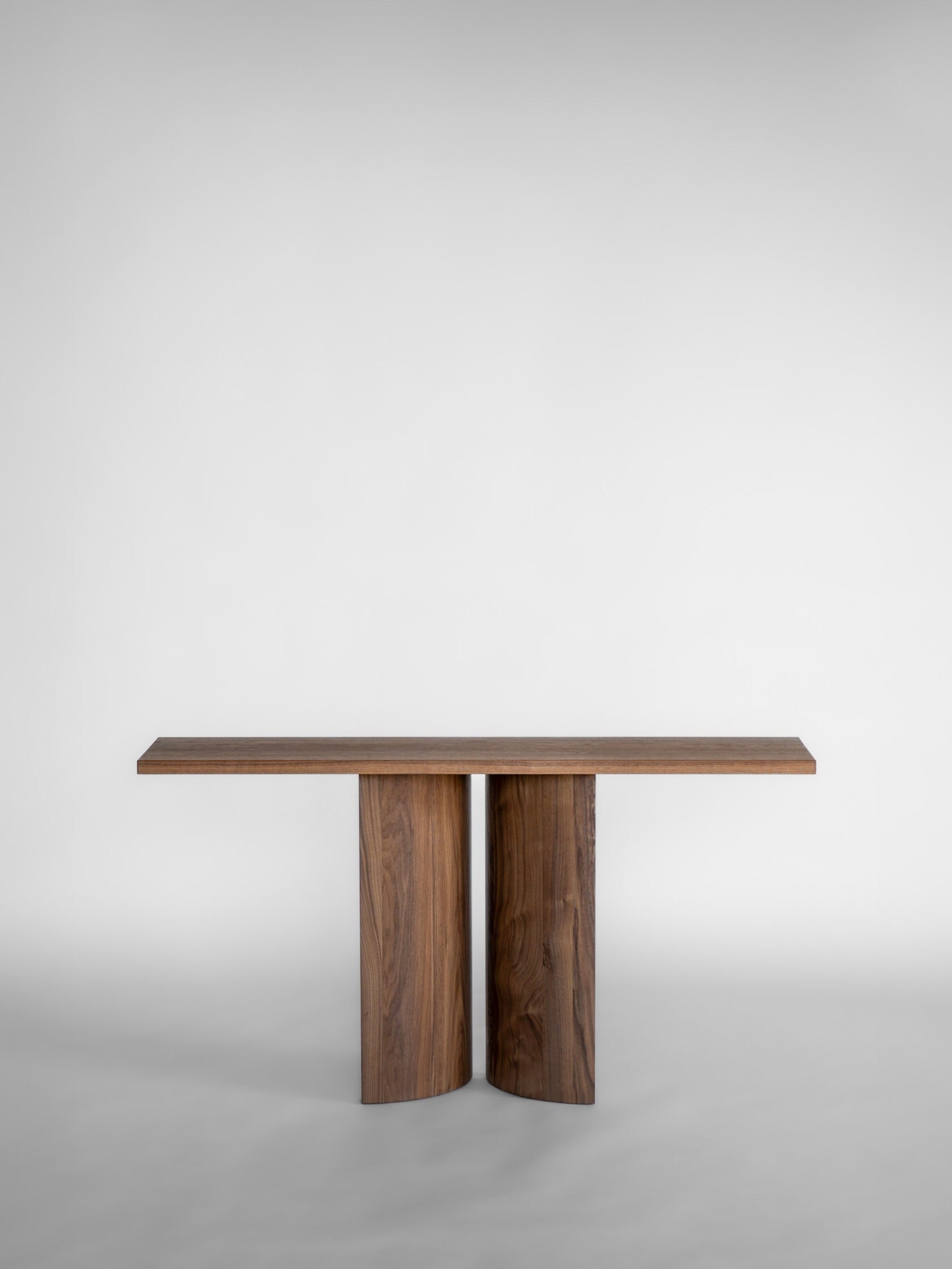 Aperta Console — top view of walnut table with two cylindrical legs