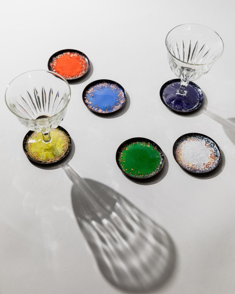 1960s Enamel Coasters Set of 6 — close-up of colorful enamel coasters on white surface