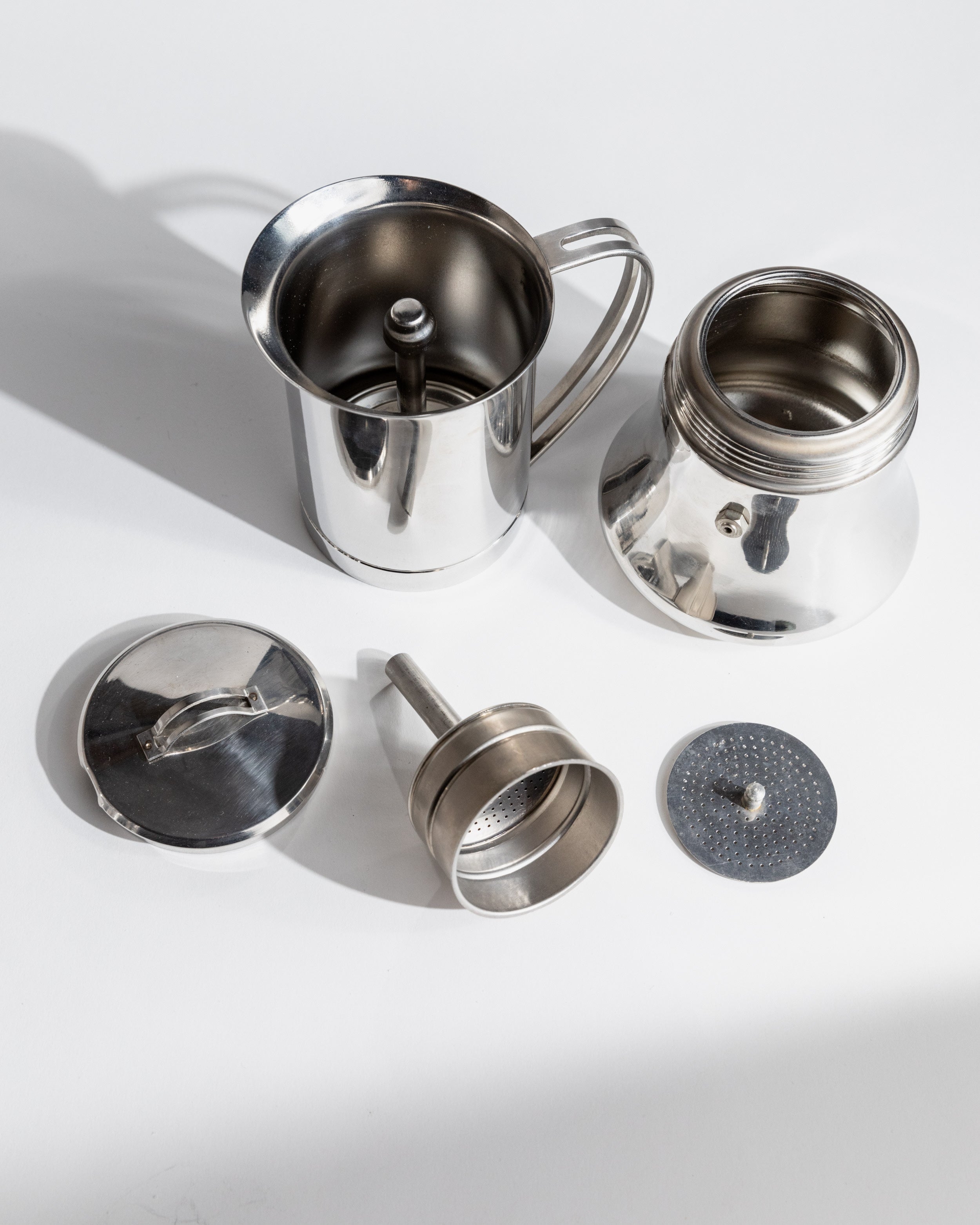 Disassembled 1980s stainless steel coffee set showing all components