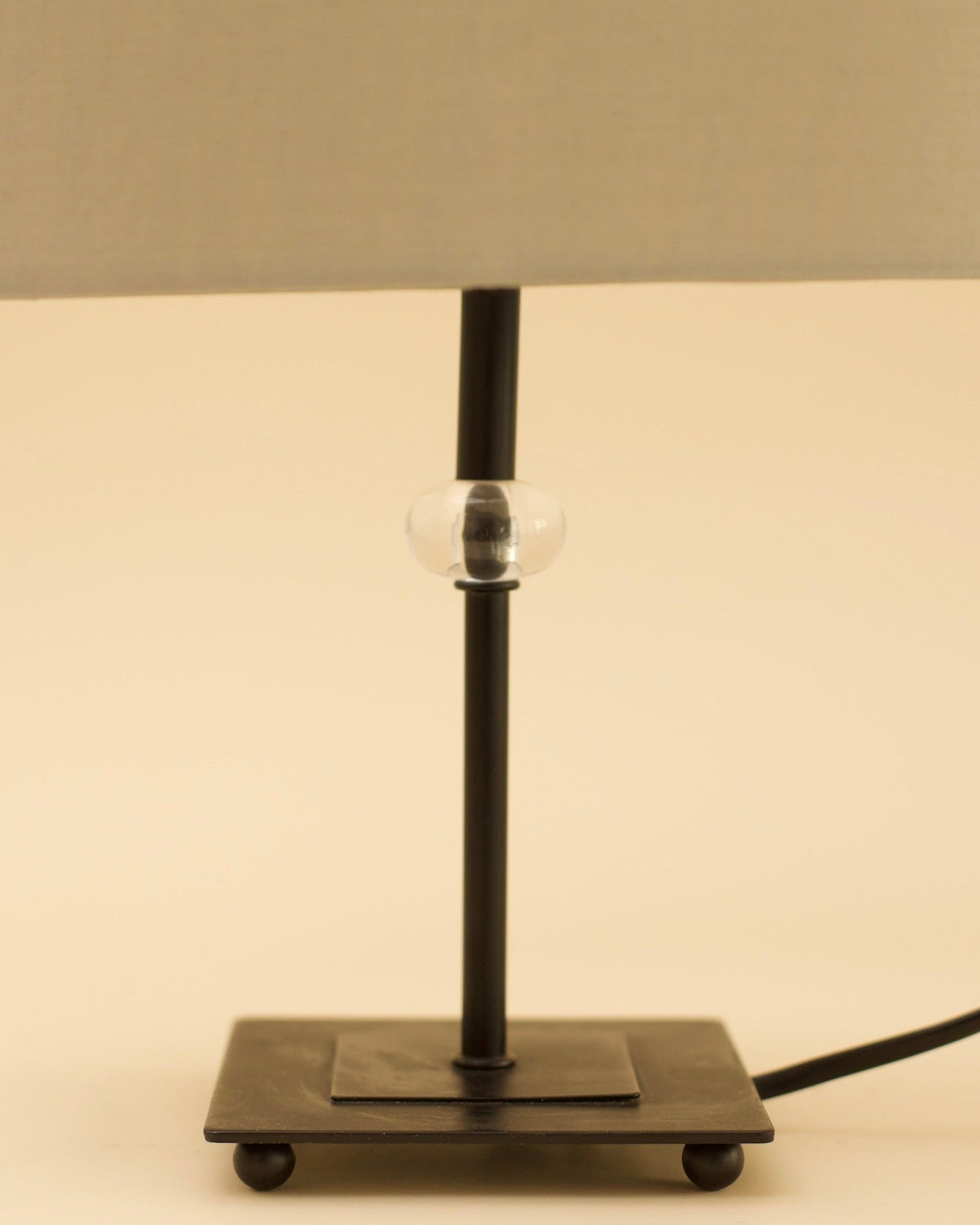 GUNTA Table Lamp — side angle showing black metal base and clear glass detail