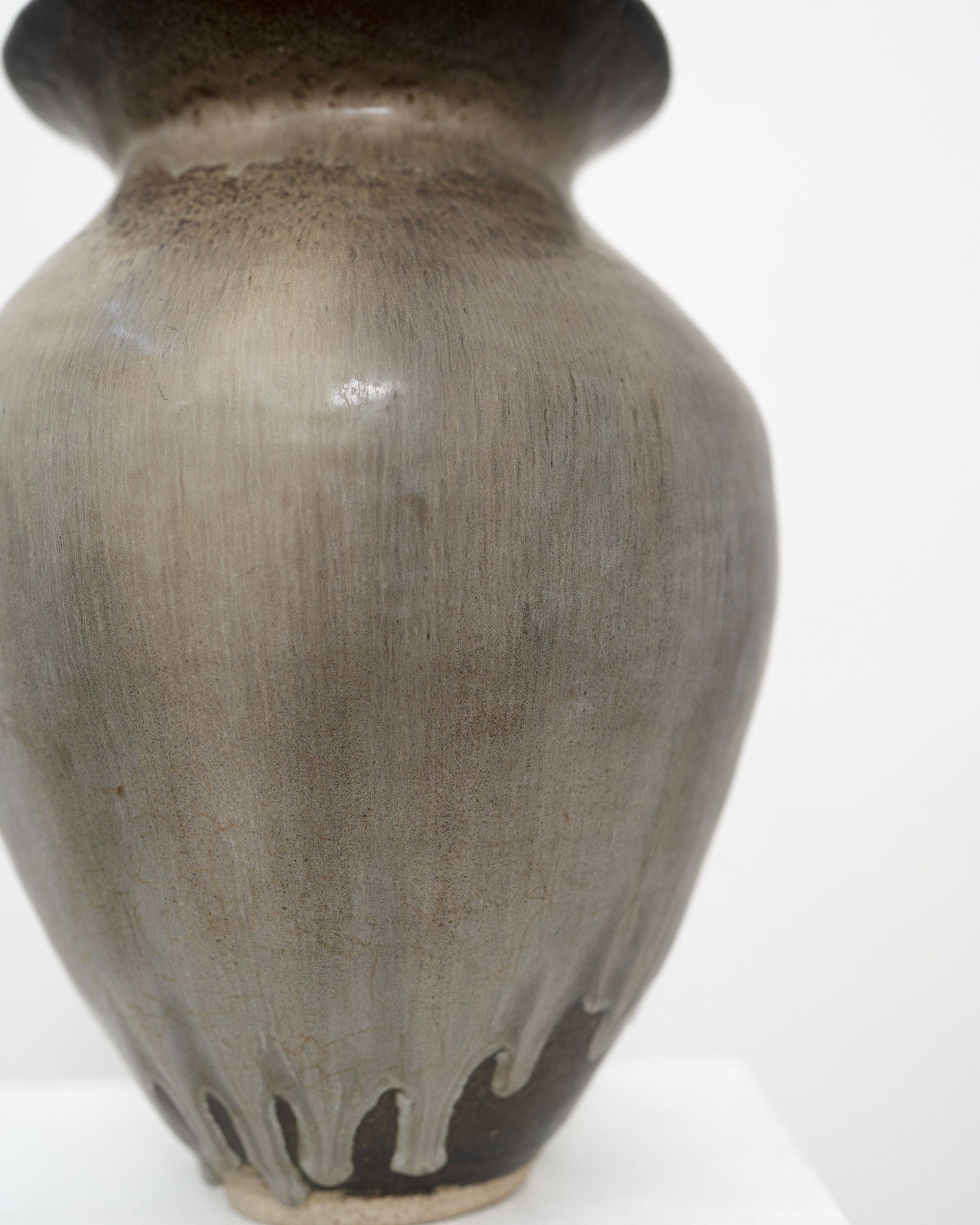 A close-up of the Hand Built Studio Pottery Vase by Tom Bogle, featuring smooth grayish stoneware with darker glossy drips from rim to base, set against a plain white background.