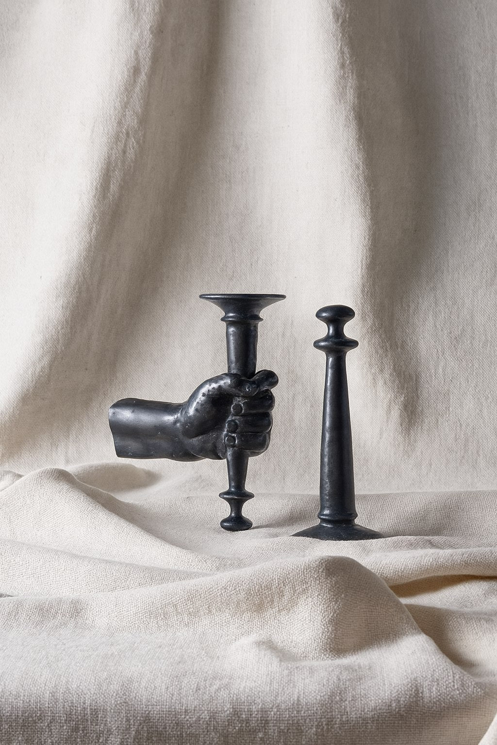 Hand-Torch Wall Light — top view of black metal design on fabric
