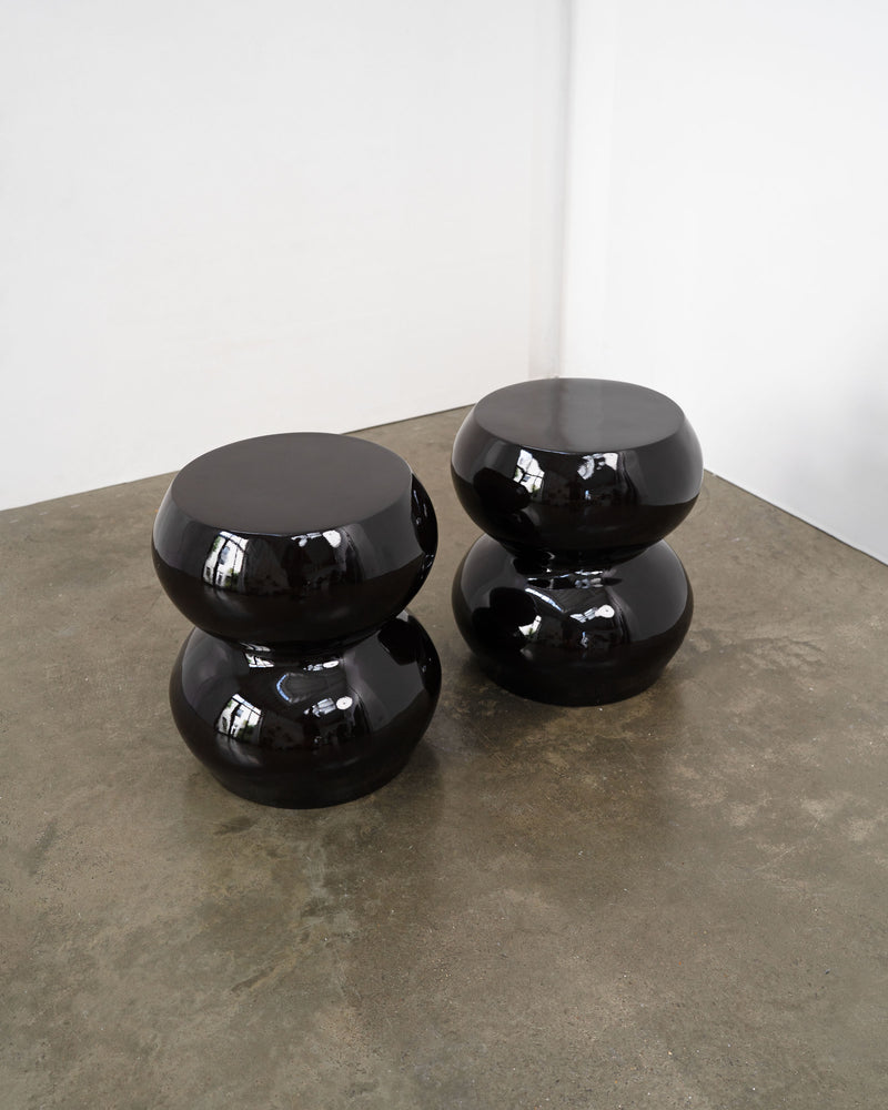 Black glossy sculptural stools stacked on concrete floor, 1970s
