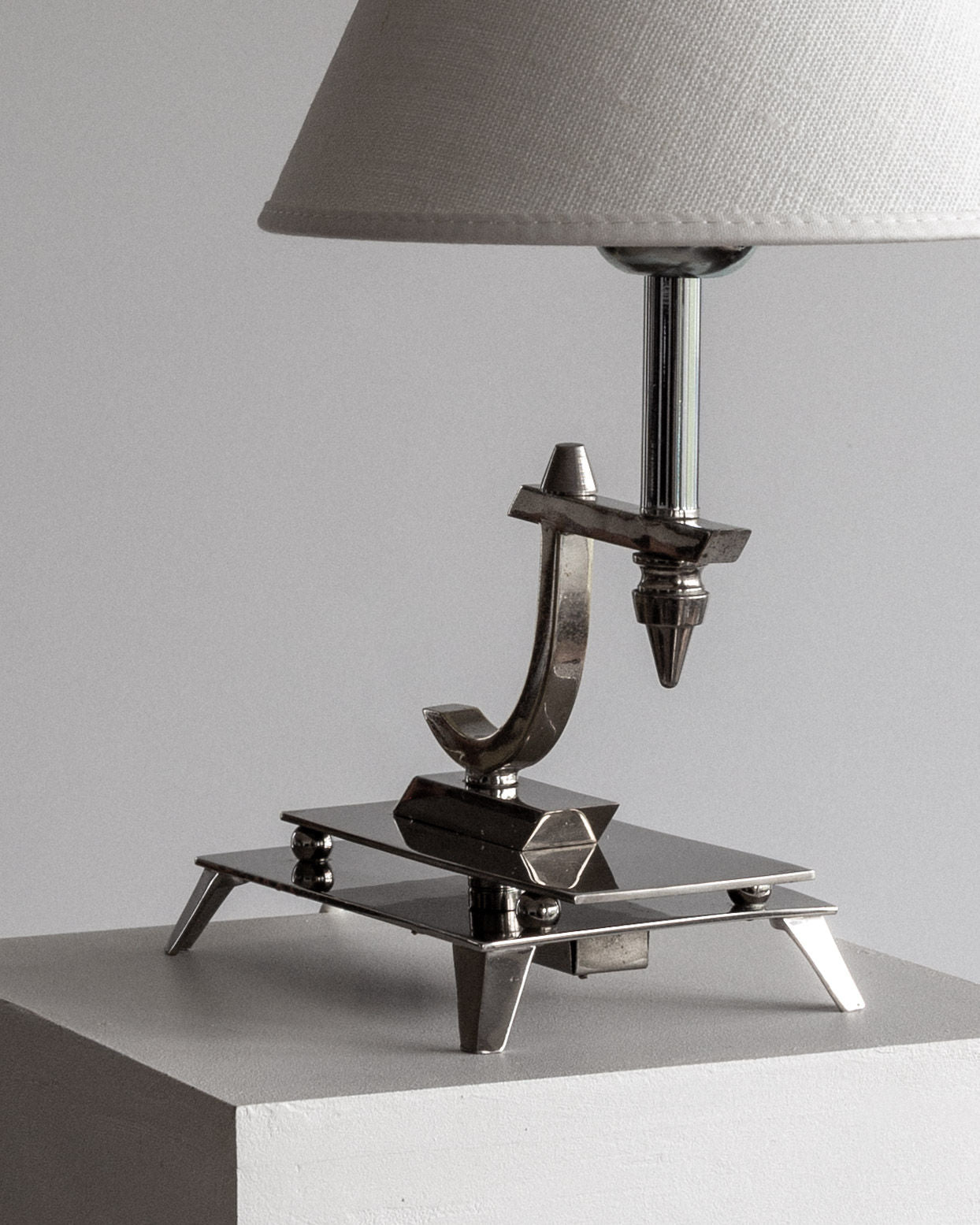 Sculptural Chrome Art Deco Table Lamp, 1930s — angled view on white pedestal