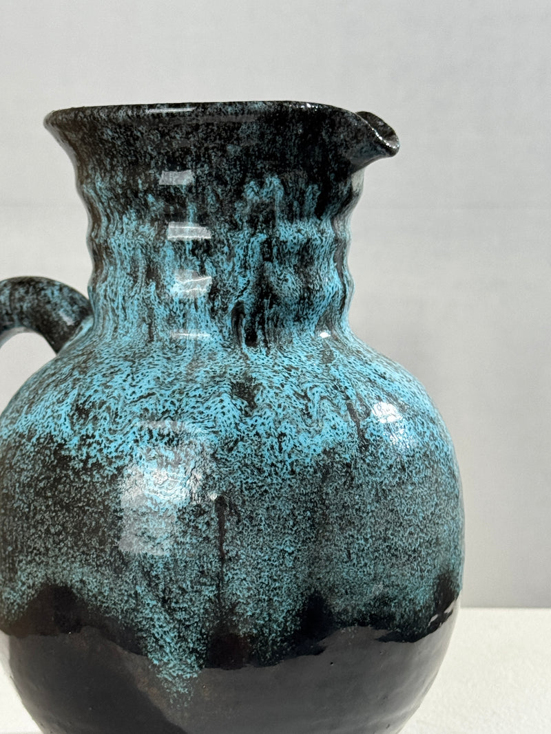Turquoise glazed ceramic pitcher detail showing textured surface