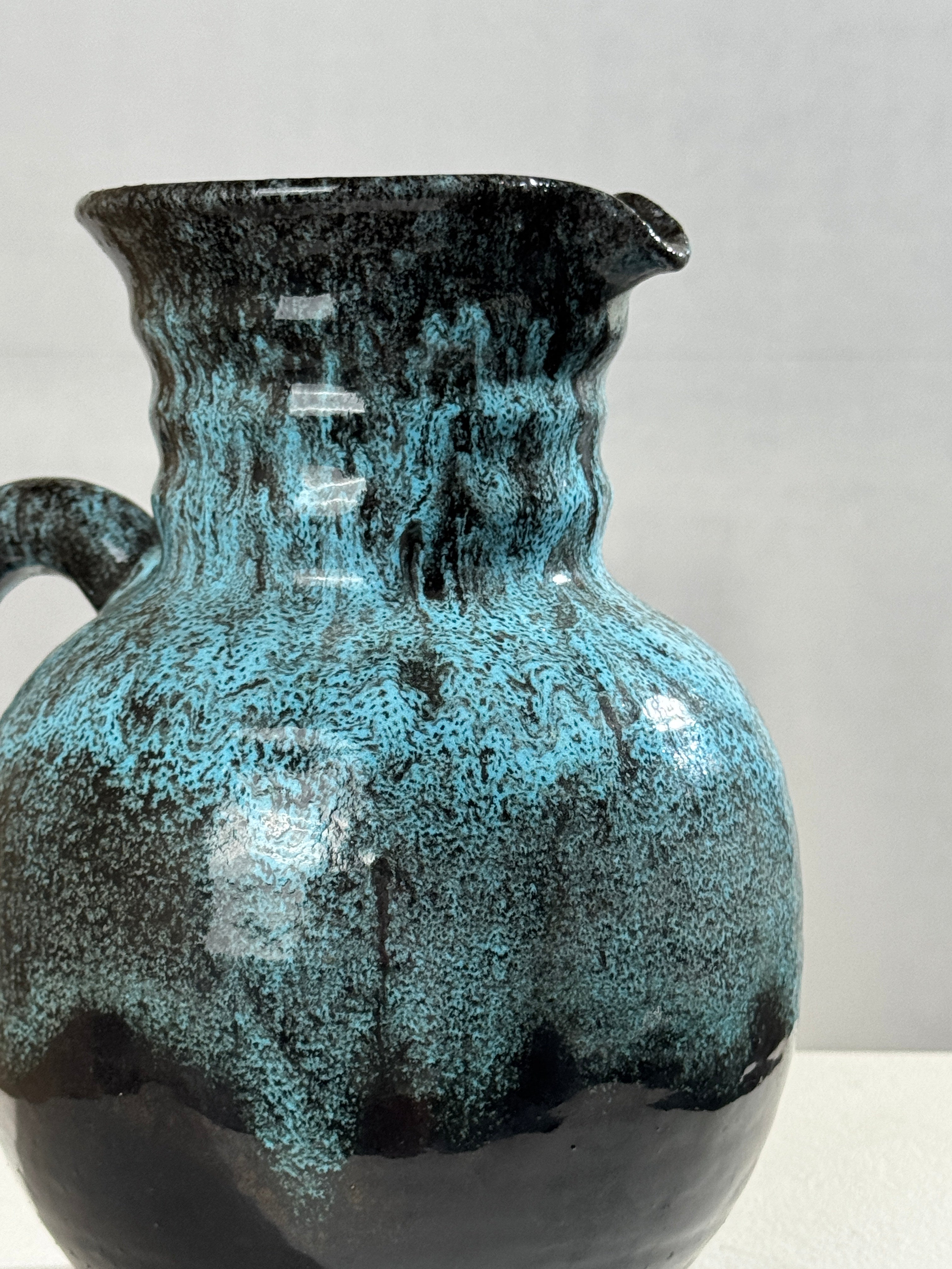 Turquoise glazed ceramic pitcher detail showing textured surface