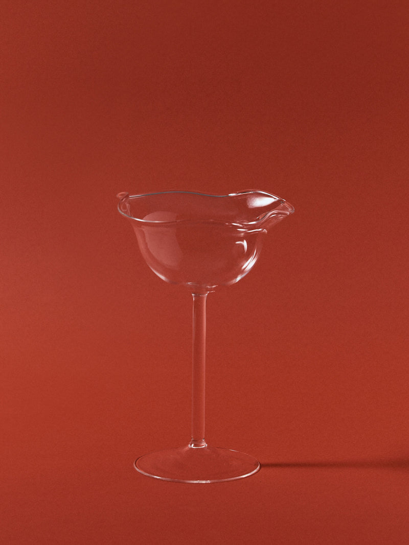Clear glass Virgo wine glass with sculptural rim on red background