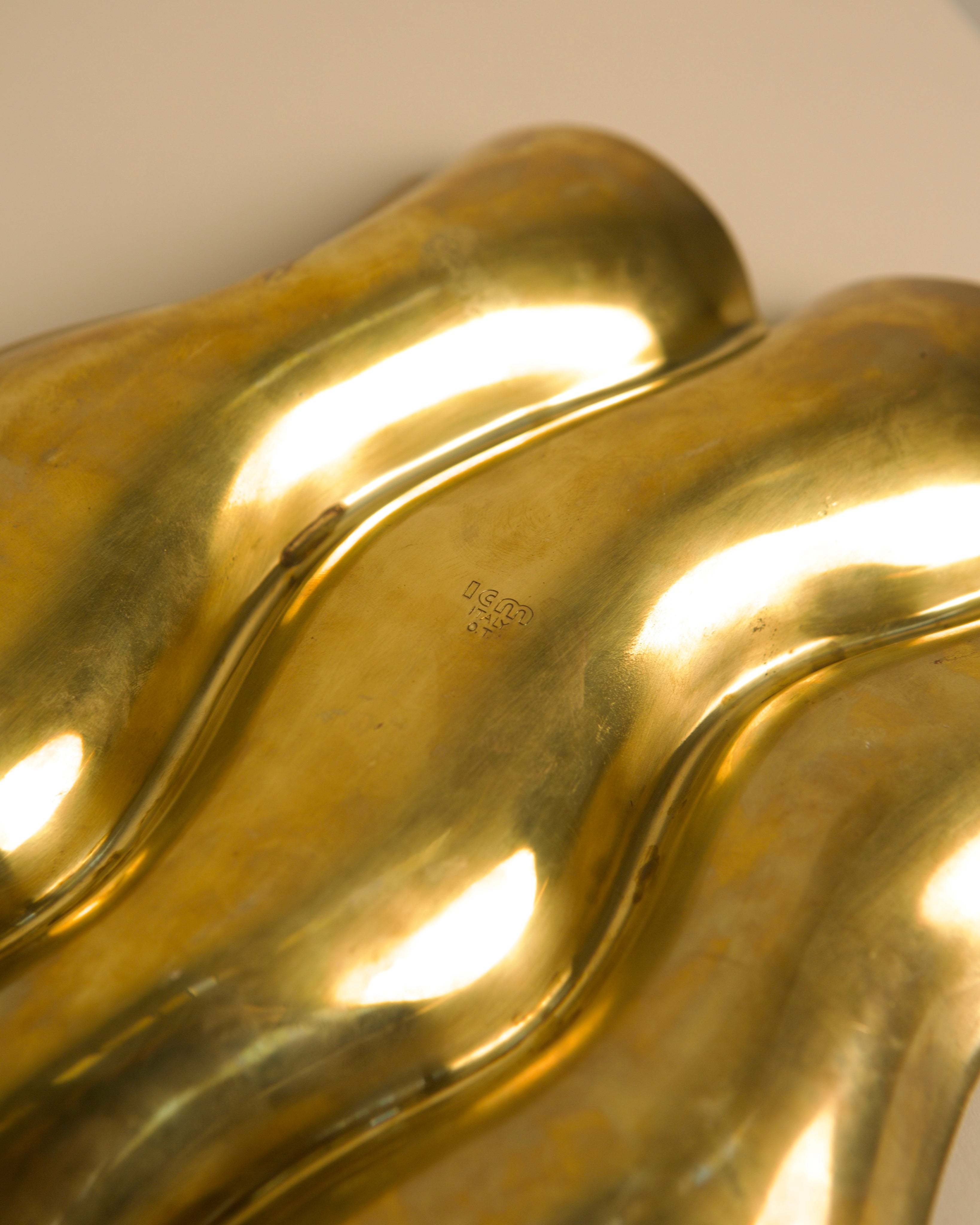 Close-up detail of golden brass Boca vide-poche curved forms