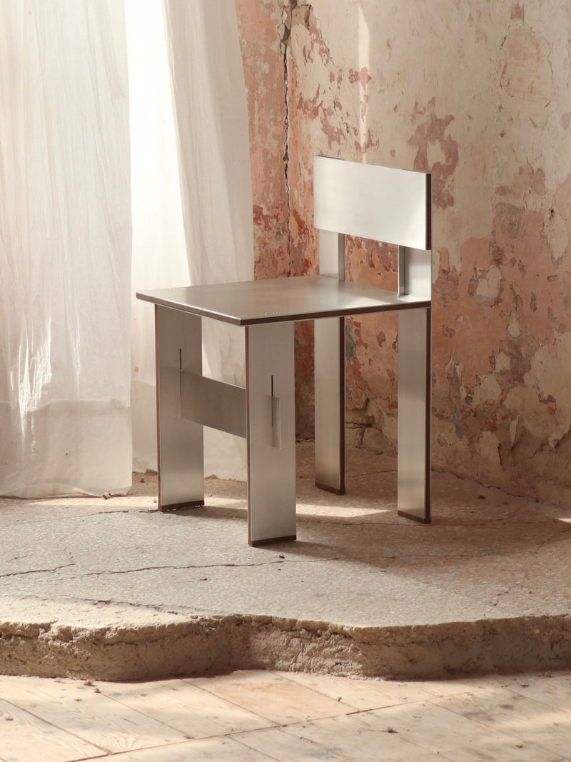 Sandwich Chair — close-up of stainless steel frame in rustic setting