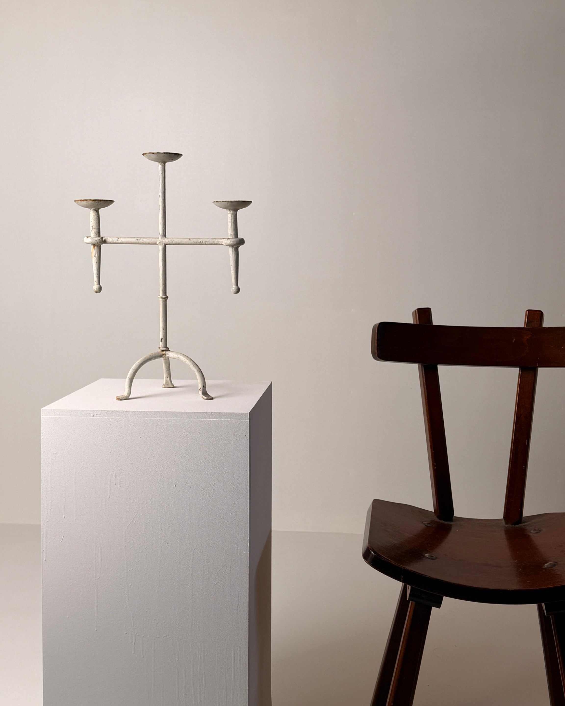 White-patinated Iron Candelabrum, France, early 20th century — front view on white pedestal