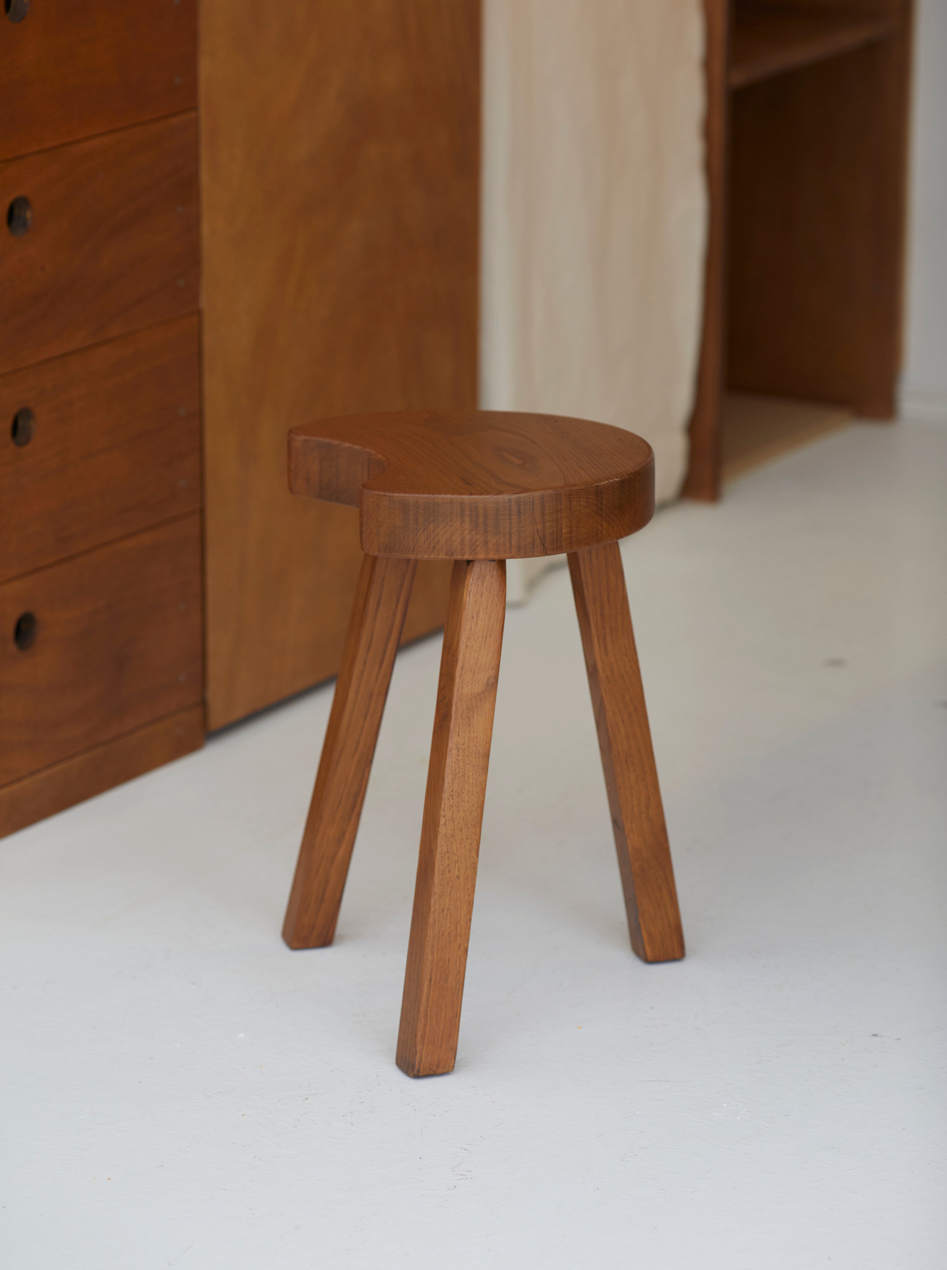 Vintage French handcrafted tripod stool in brutalist style, solid beech wood C. 1960 — side angle showing three wooden legs a