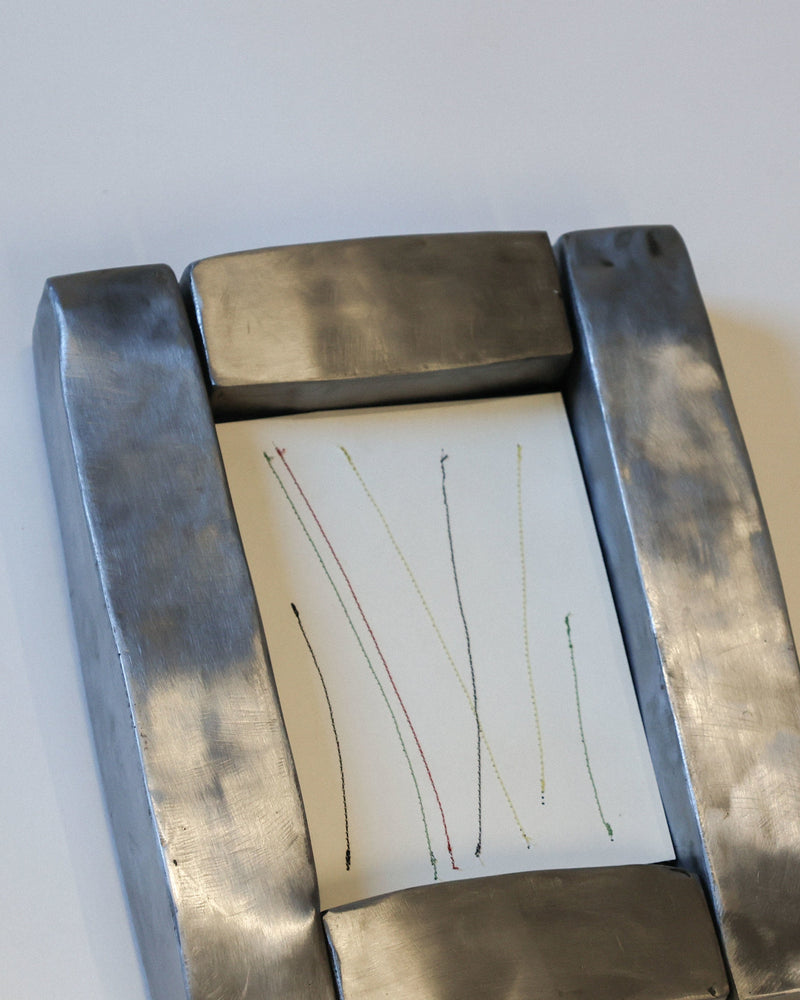 Hammered steel frame displaying colorful thread artwork detail