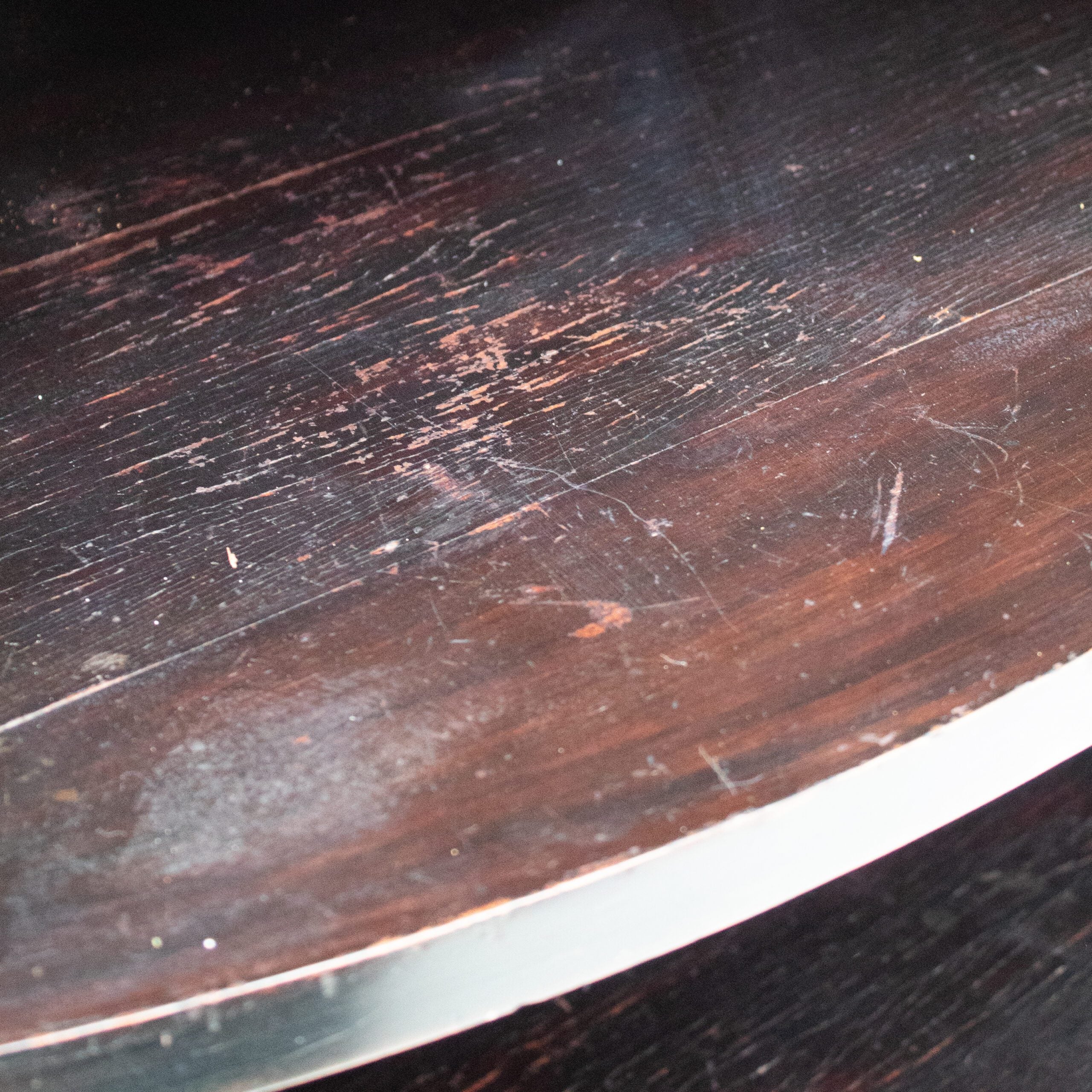 Art Deco Cabinets — close-up of dark wood surface with metal edge