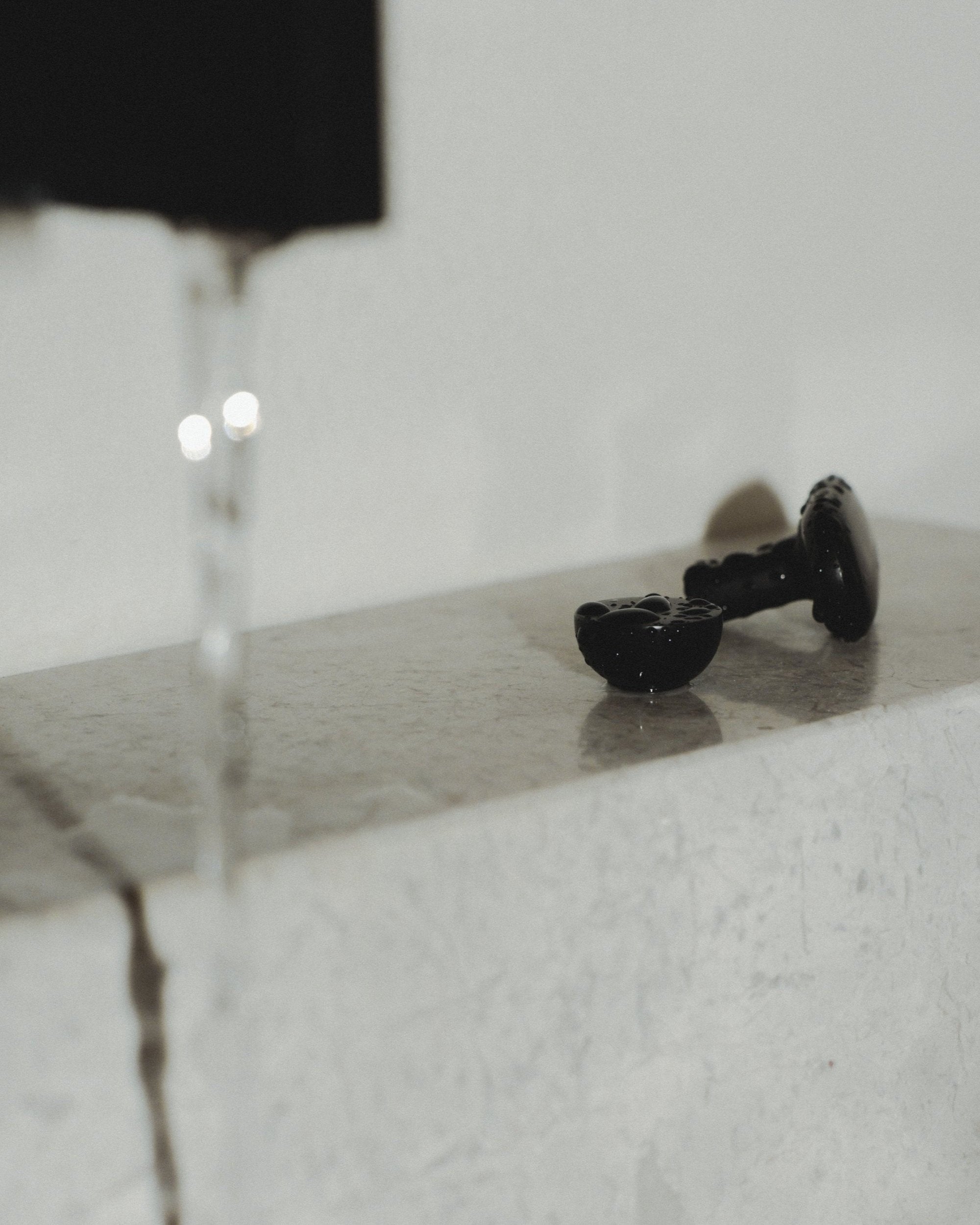 CERCLE Cabinet Knob Half — top view of black ceramic knob on marble