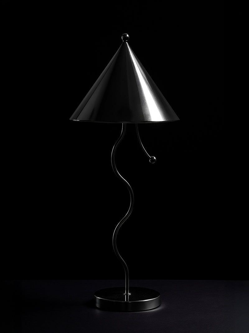 The Dodo Vintage Postmodern Wavey Chrome Table Lamp features a sculptural wavy metal stand, a shiny conical shade, and a chrome-plated finish, creating a striking minimalist statement against a dark background.