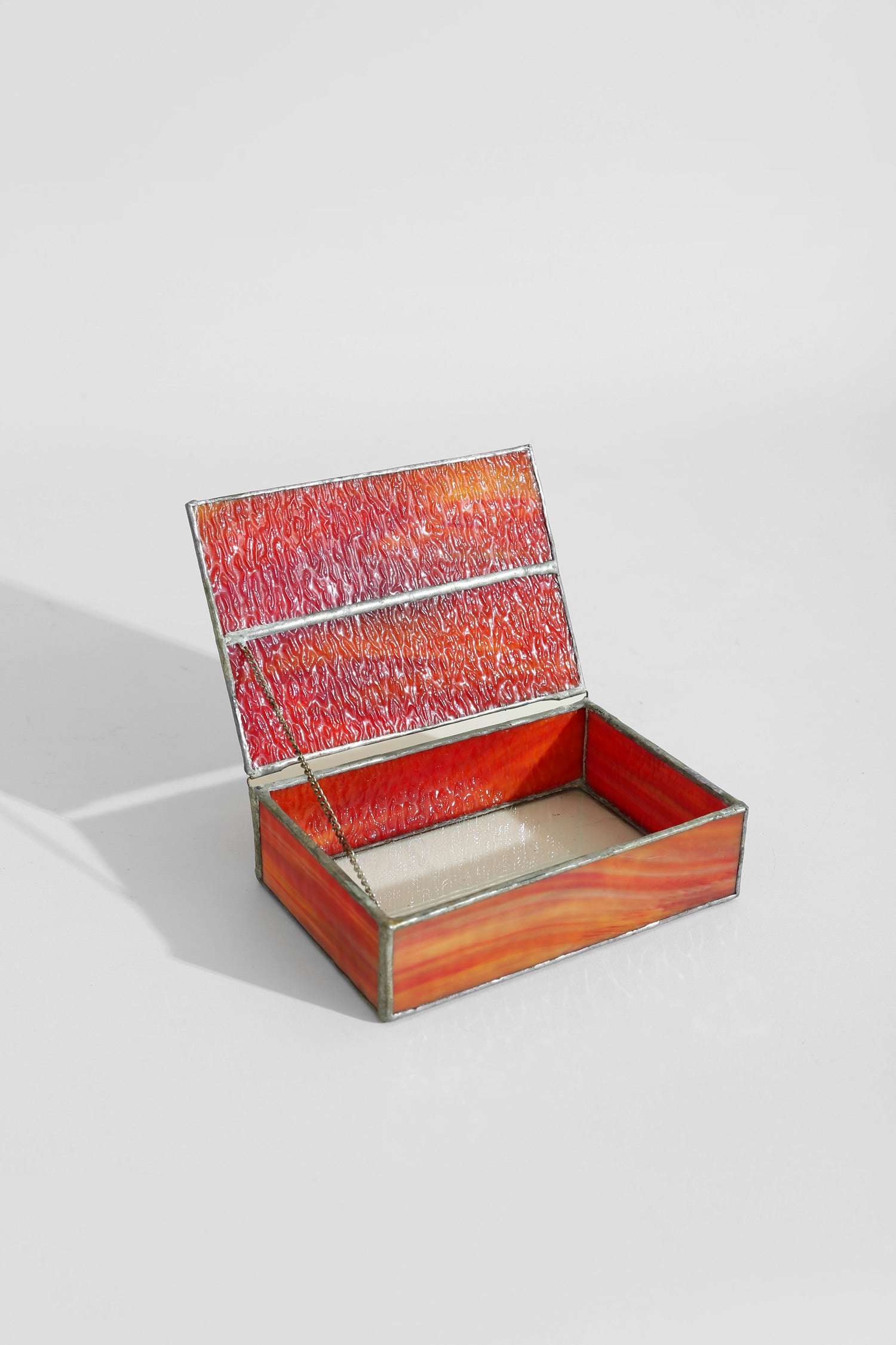Spiral Shell Glass Jewelry Box — side angle with open red glass lid