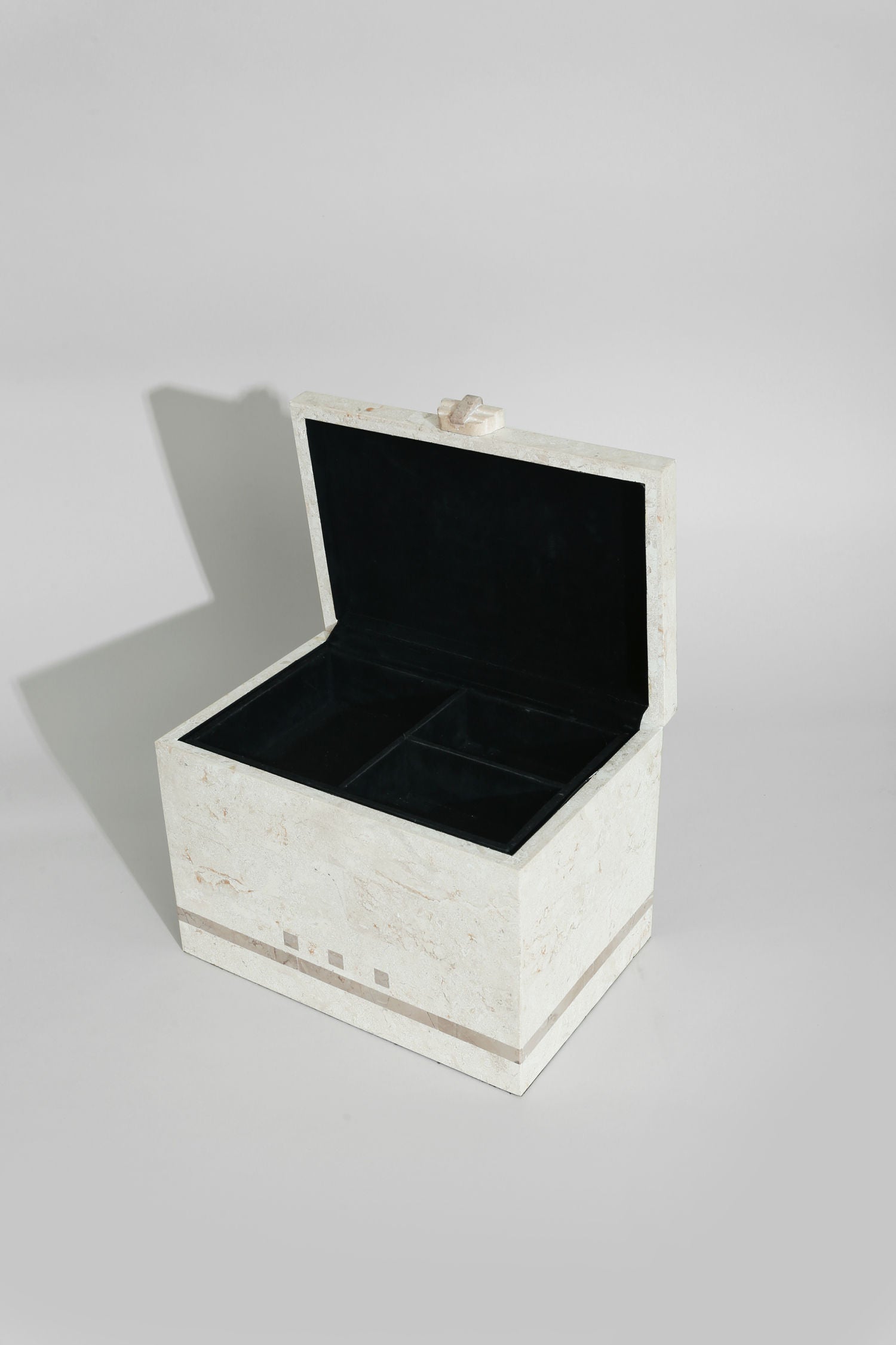 Open tessellated stone jewelry box with black velvet interior