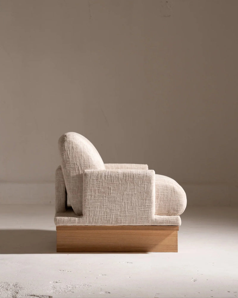Apausa 2 beige linen armchair profile view on wooden base