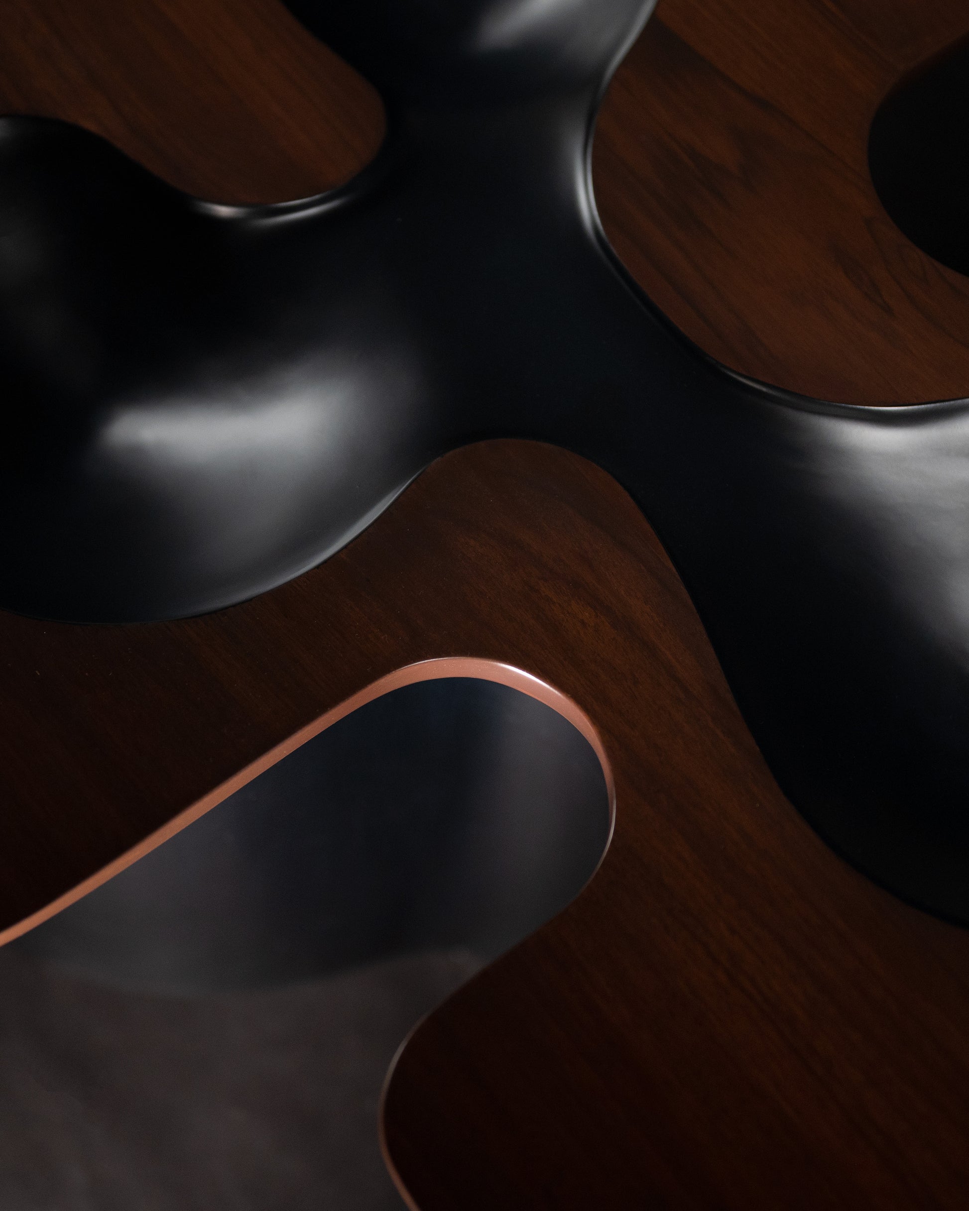 Canyon Centre Table — side angle showing black surface and copper edge