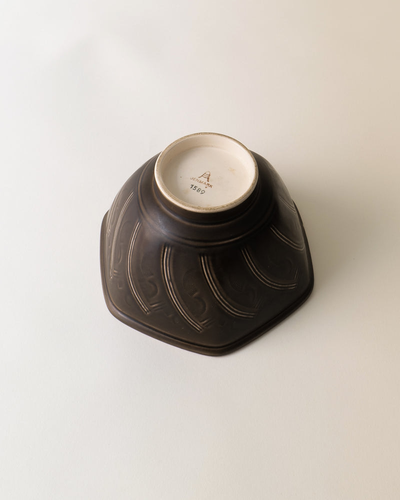 Underside view of ceramic bowl showing maker's mark and curved ridged pattern