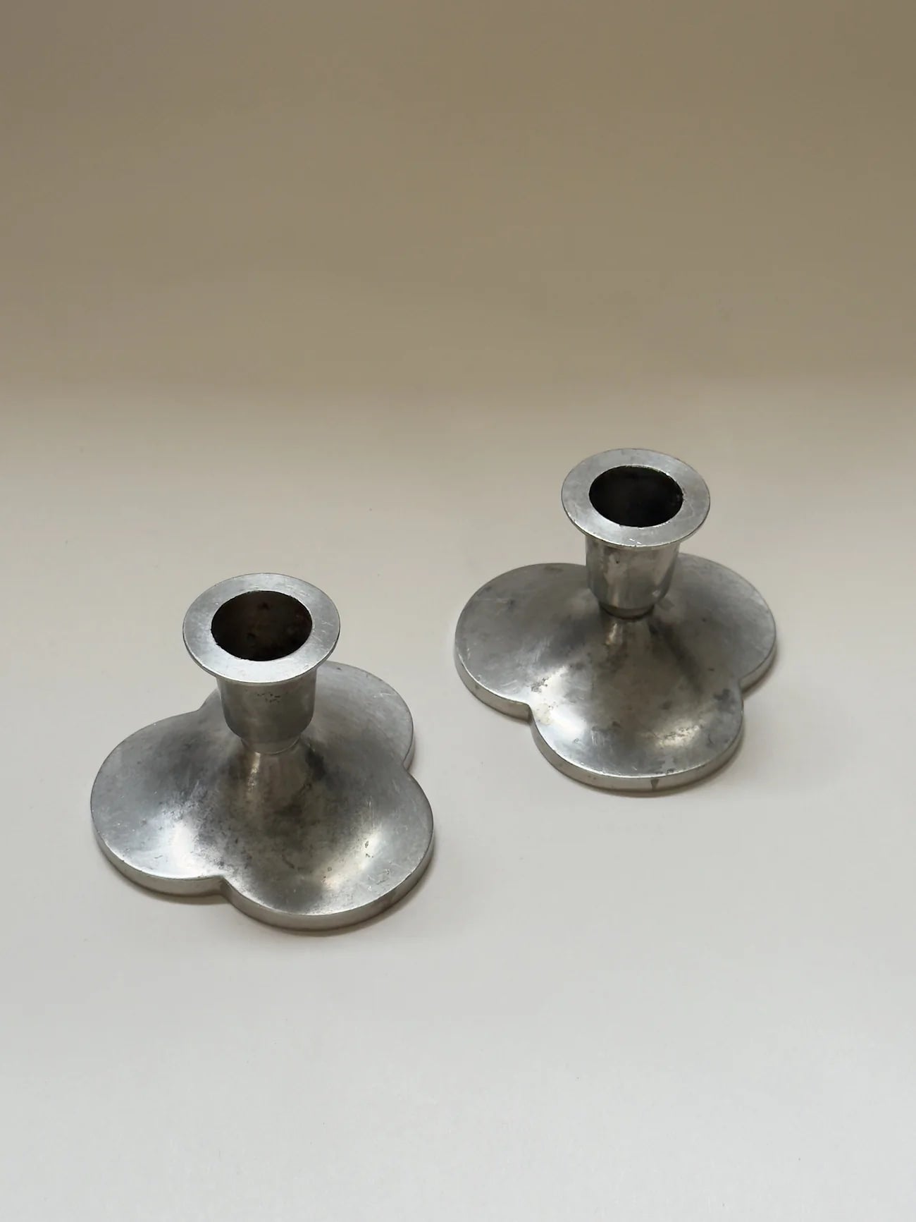 Pair of Pewter Candlesticks by Just Andersen — angled view on neutral background