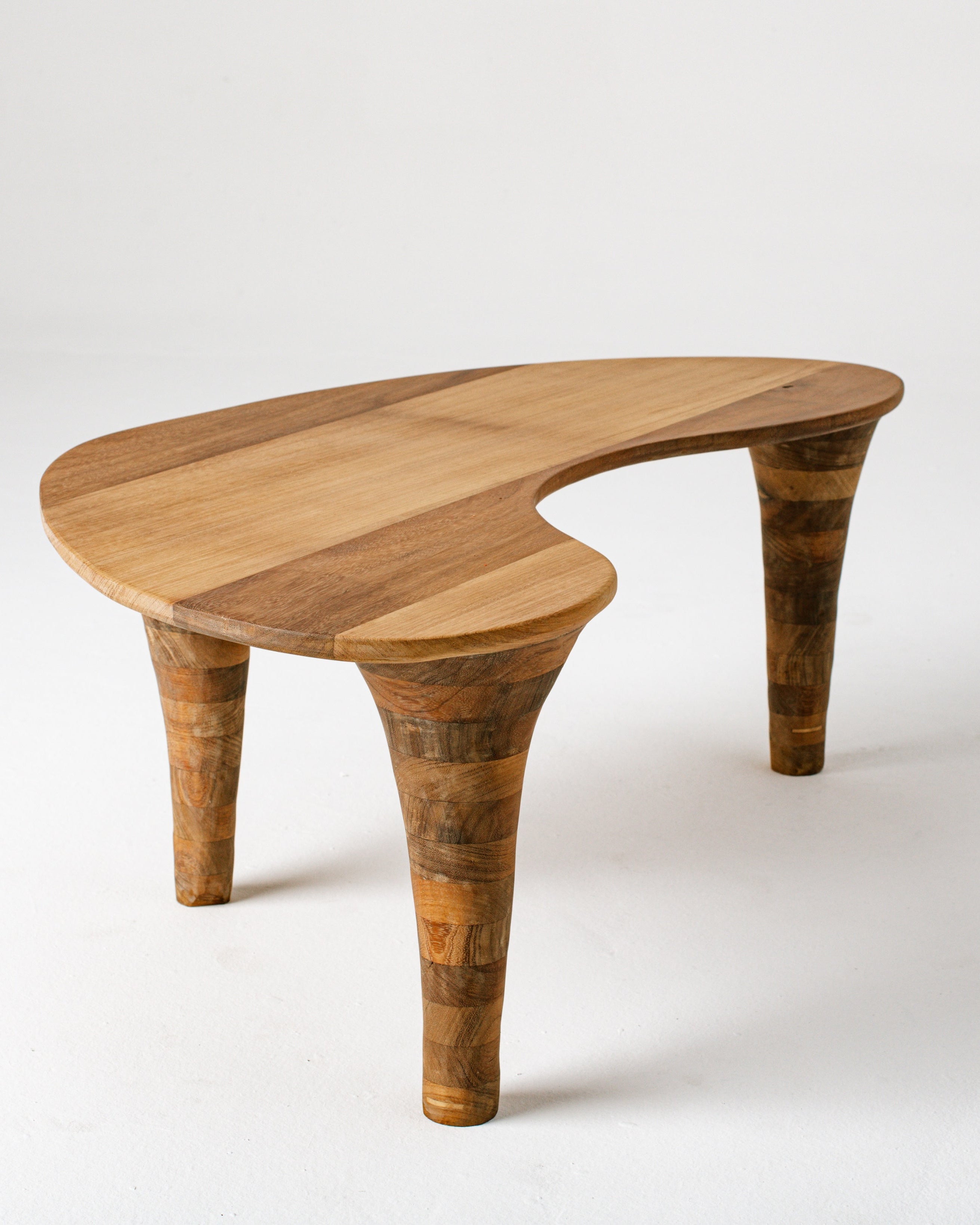 Curved organic coffee table profile showing sculptural wood legs