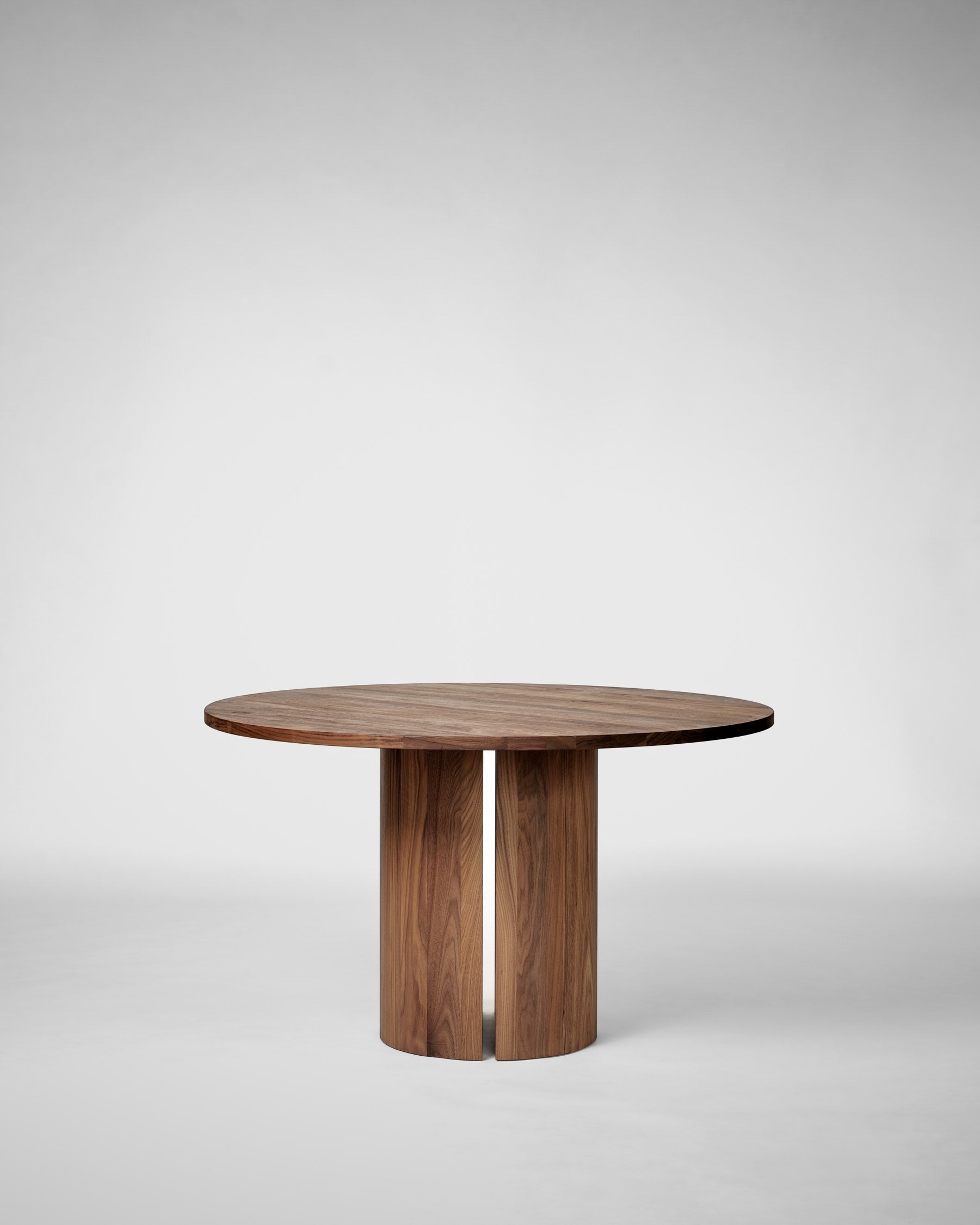 Modern walnut round dining table with cylindrical pedestal base