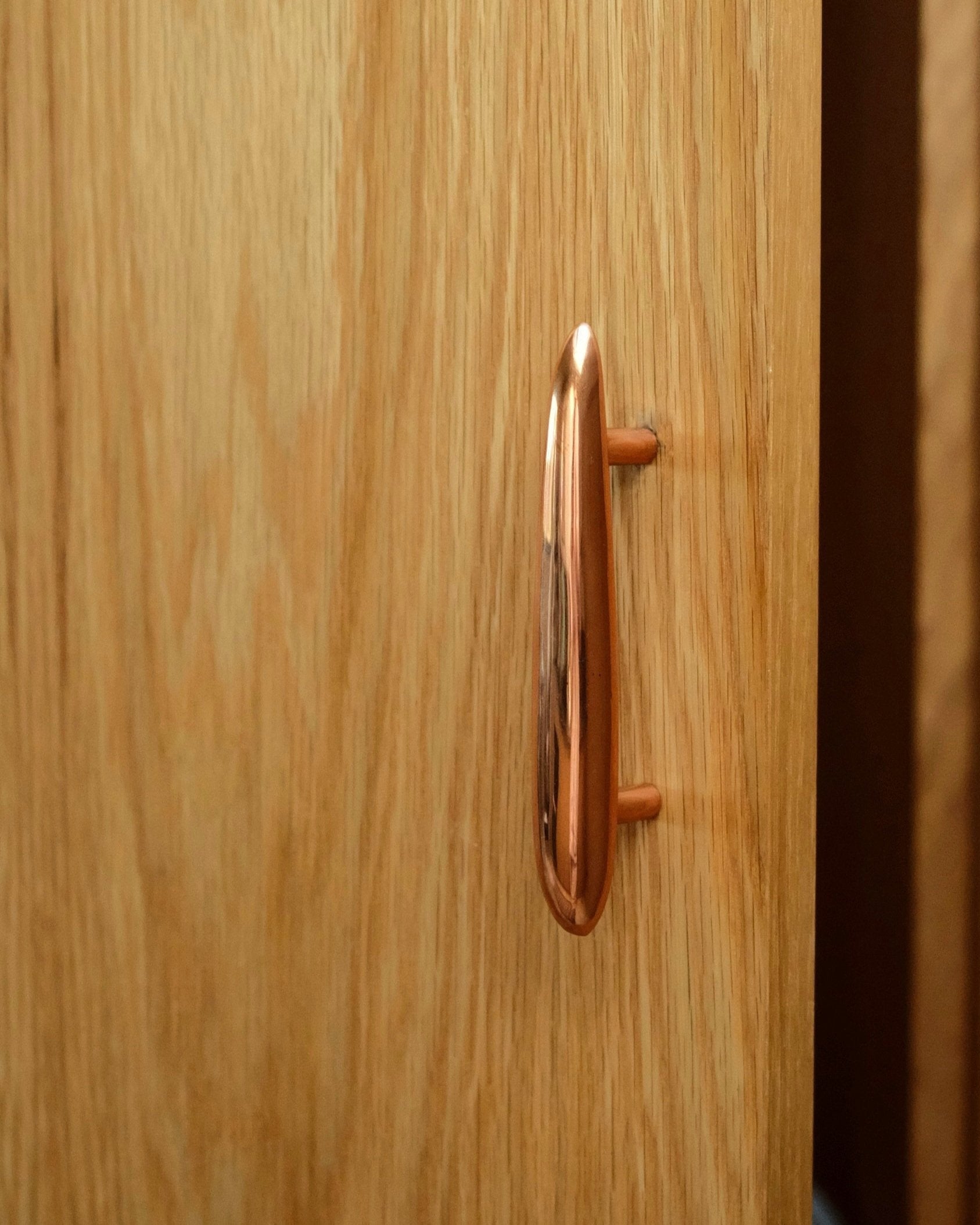 MOMI Cabinet Pull — close-up of polished copper knob on wood cabinet