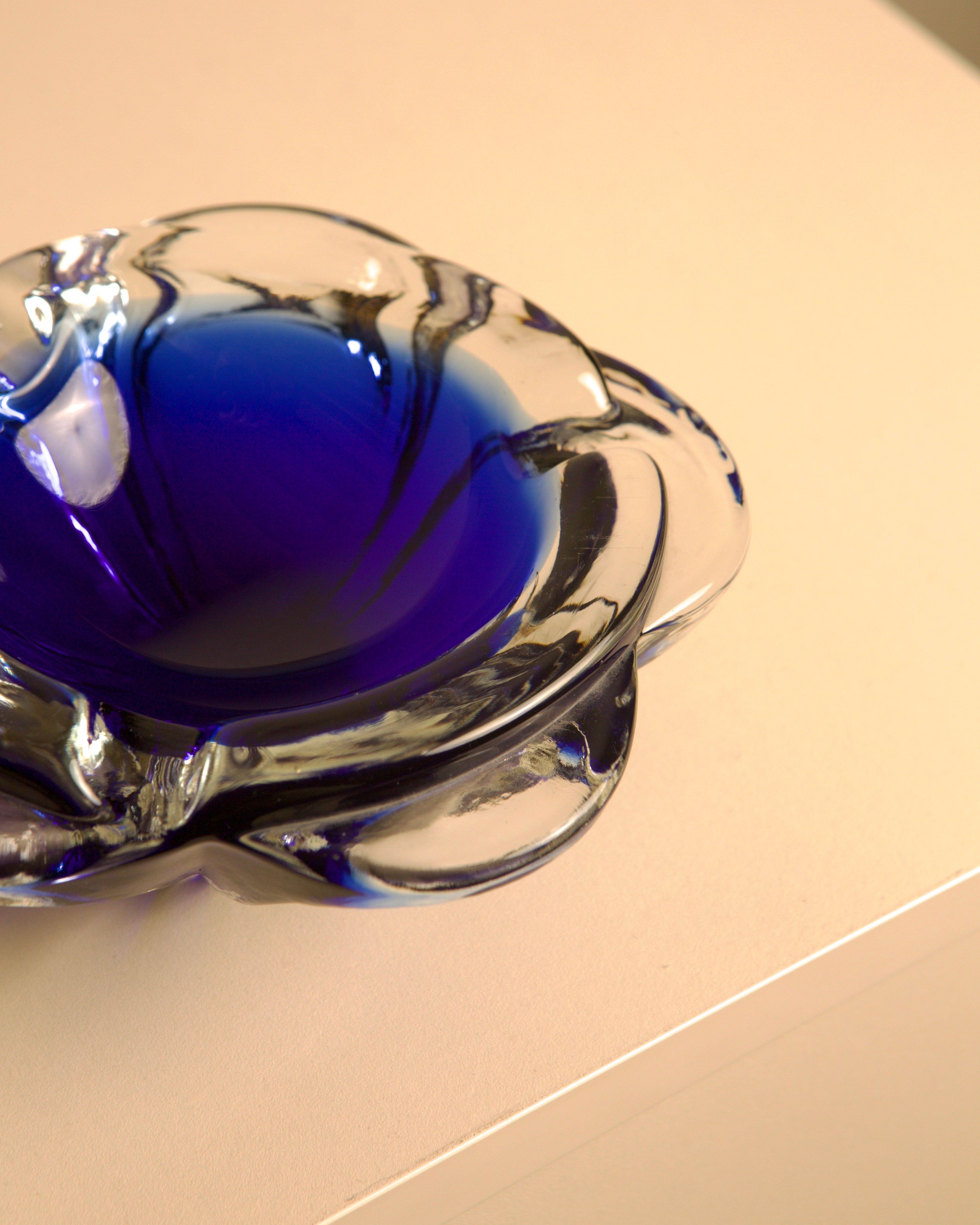 80's Blue Murano Glass "Flower" Ashtray — side angle on light surface