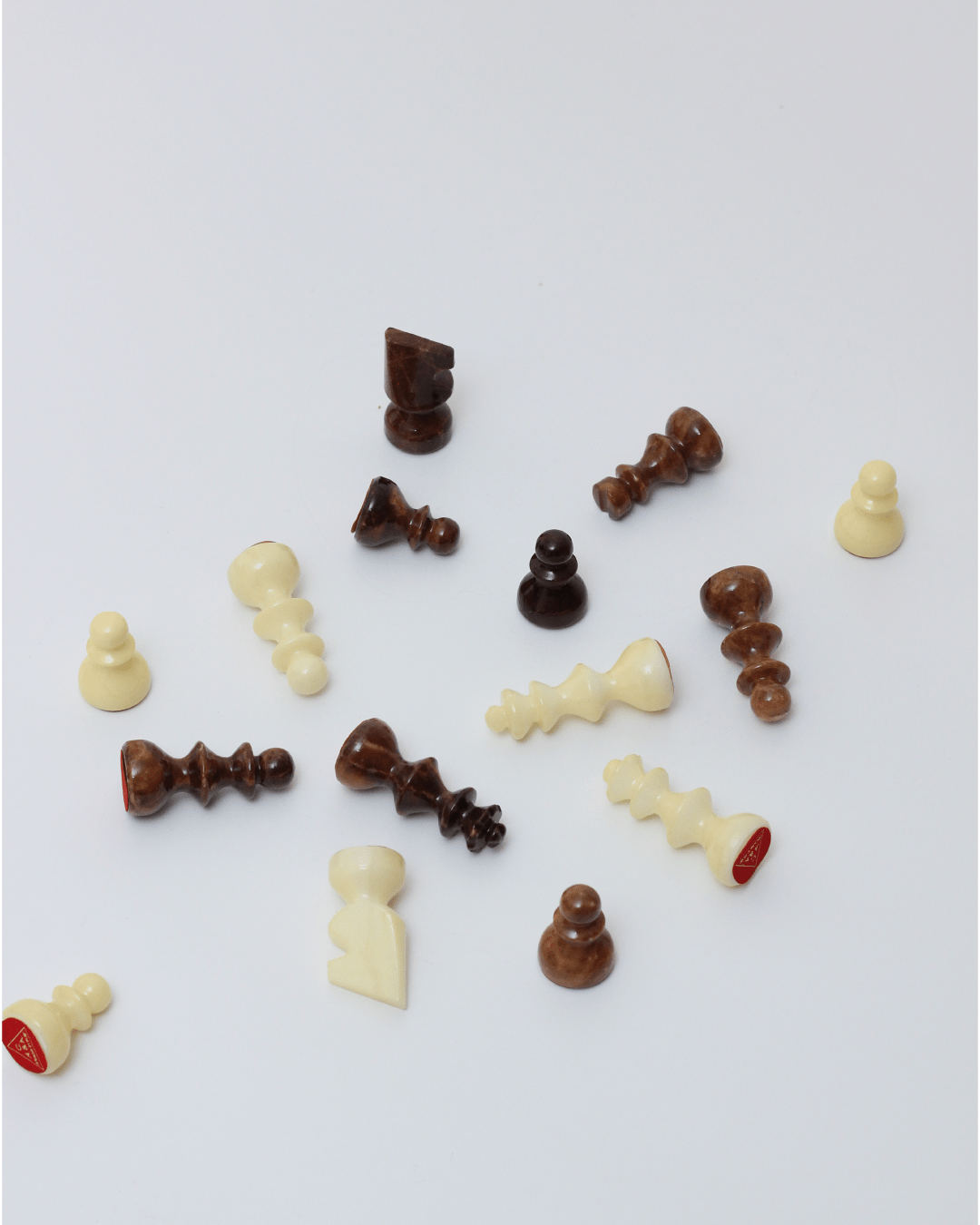 Marble Chess — scattered handcrafted pieces in cream and brown