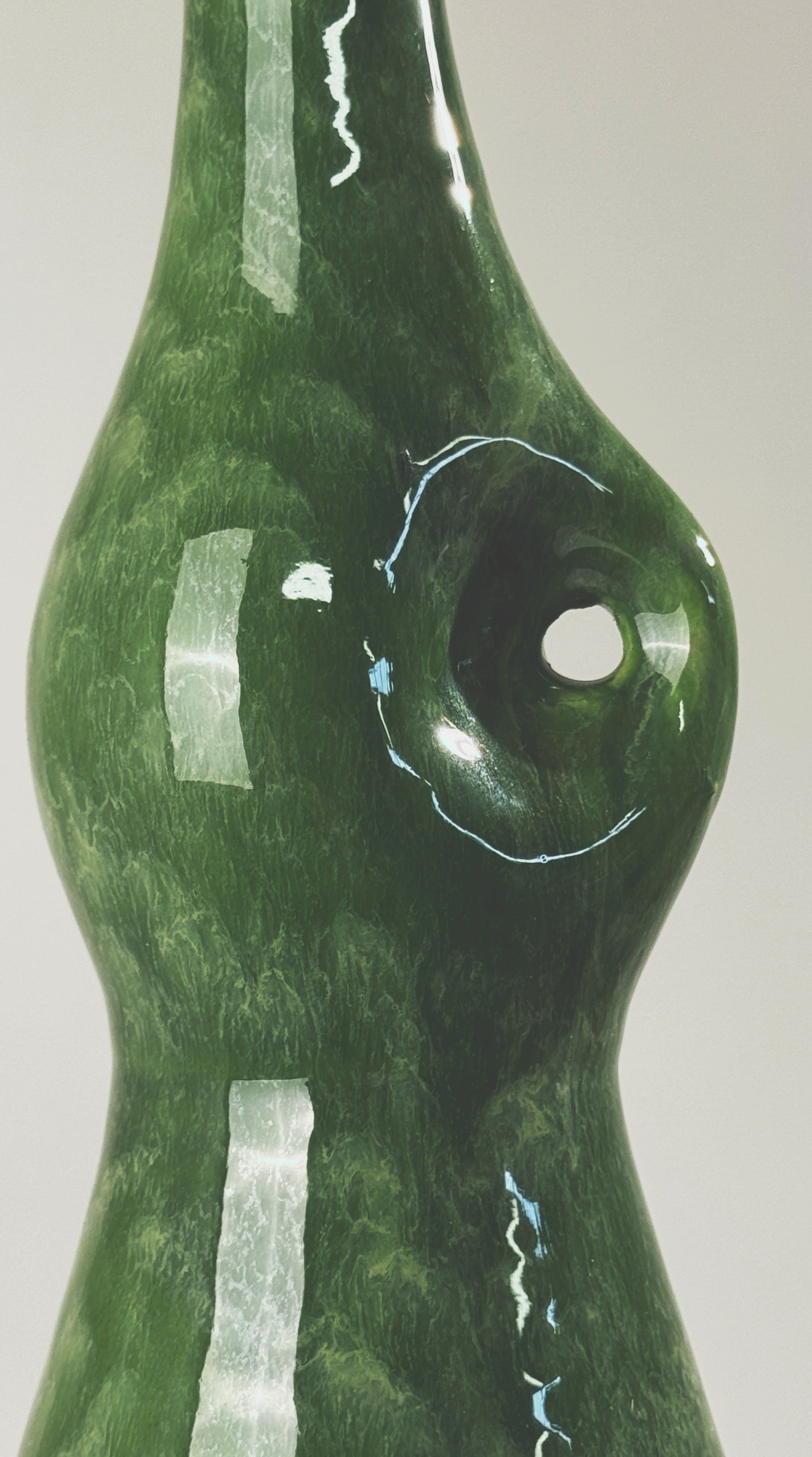 Green glazed ceramic bottle showing reflective surface detail by Accolay Potters