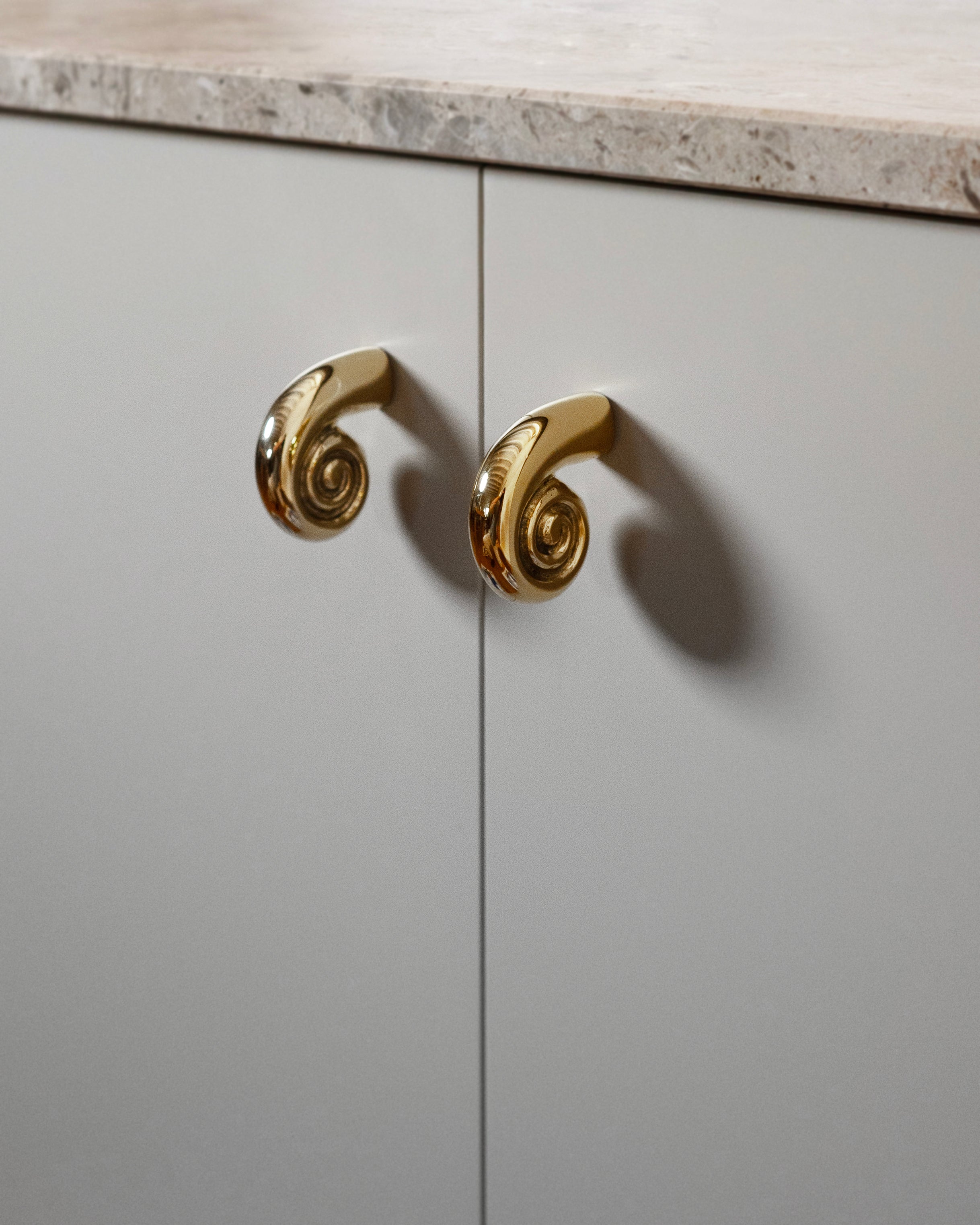 Noelle Knob - Brass — top view of brass knob on cabinet