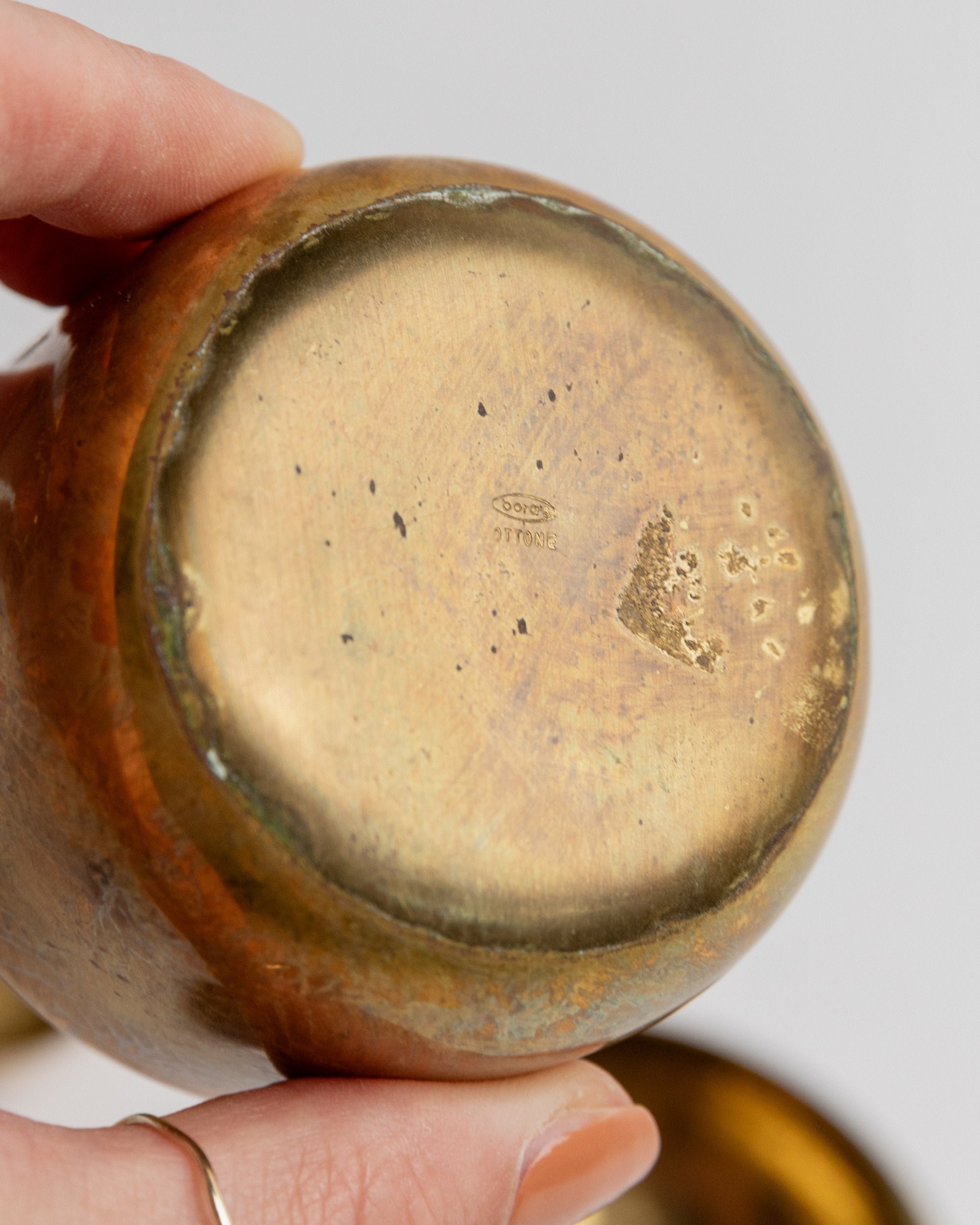 Bottom view of vintage brass tin showing maker's mark and patina