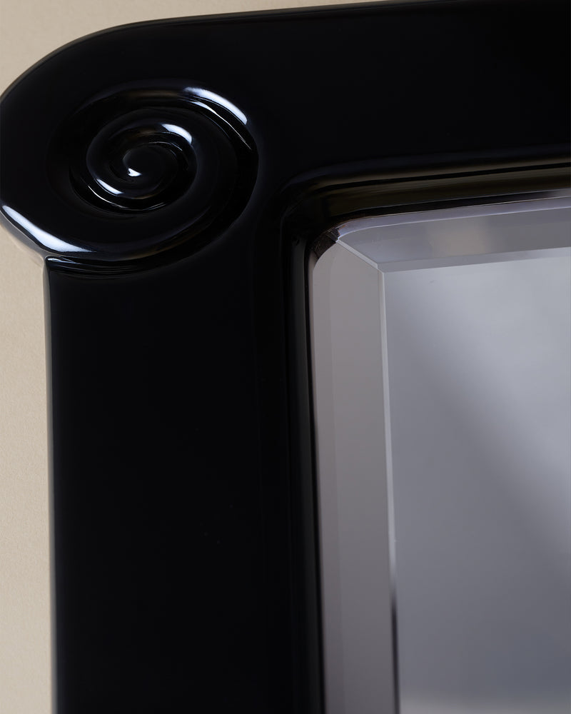 Nautilus black lacquered mirror capital detail showing curved volute