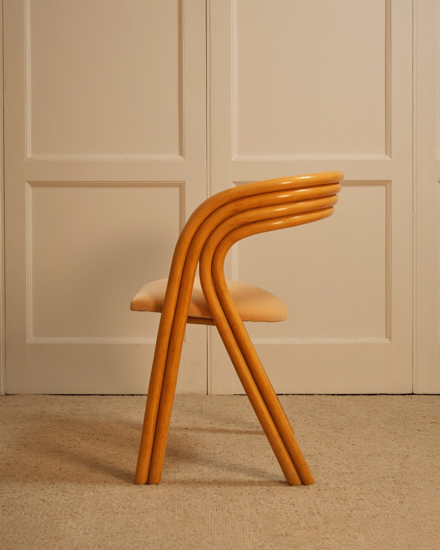 Stack of four orange bentwood chairs showing curved frame profile