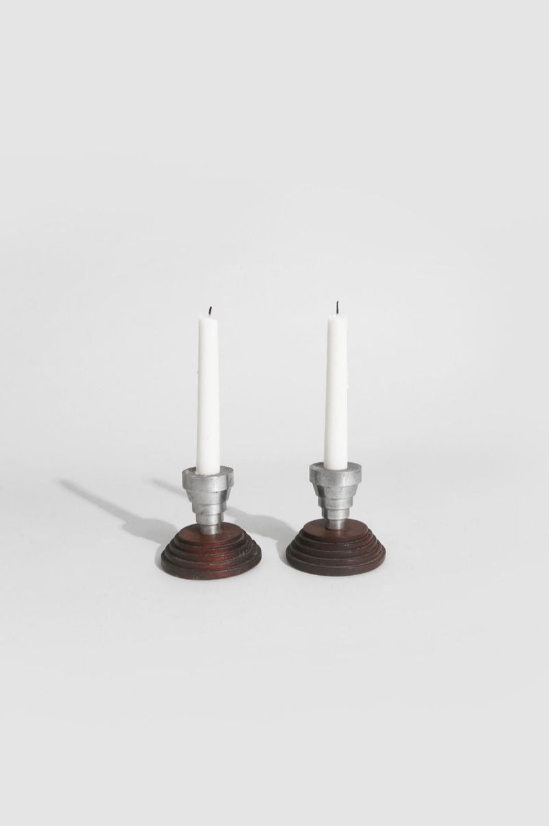 Two modern candleholders with stepped wood bases and white candles