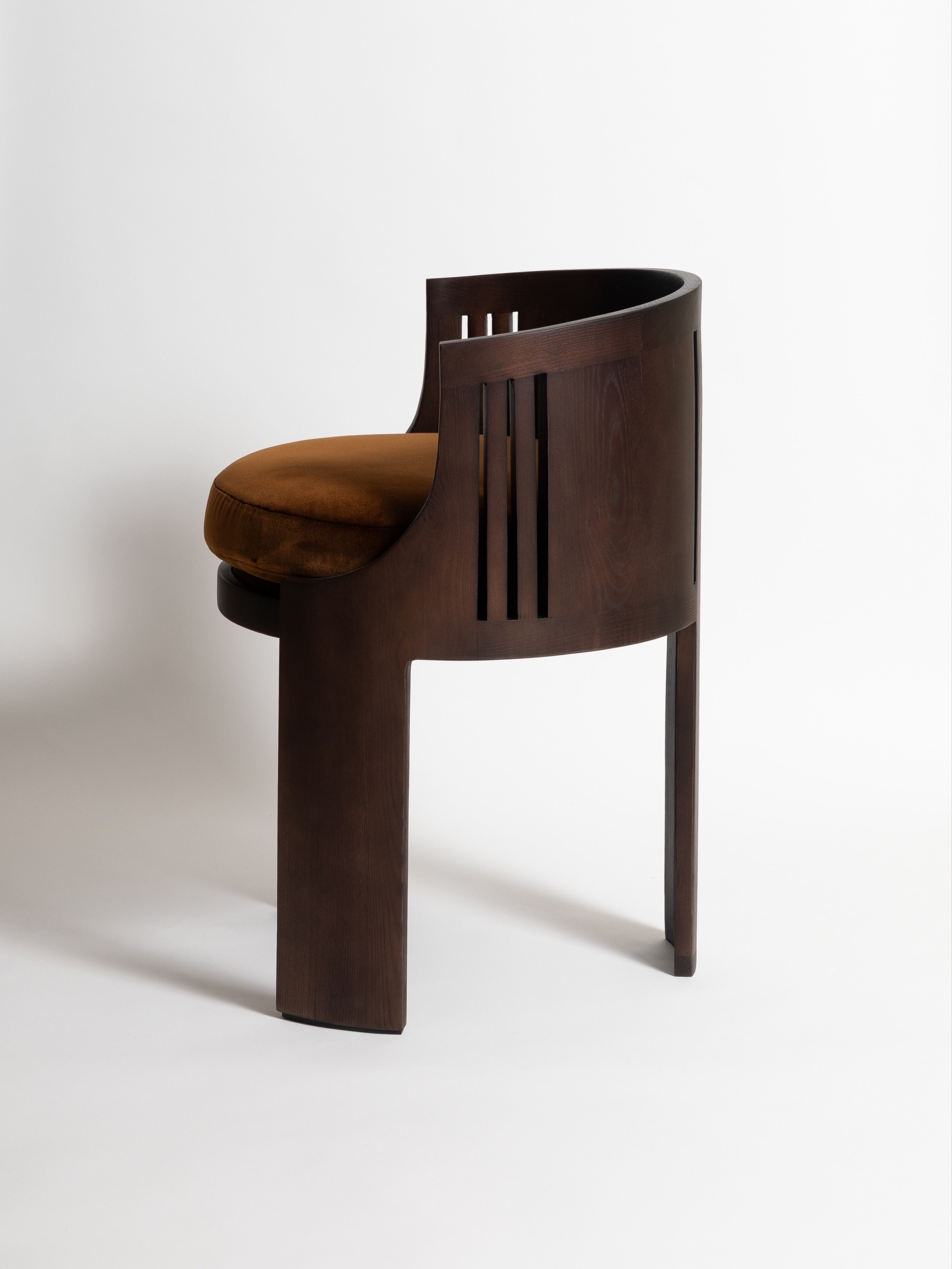 La Chaise 01 — side view highlighting dark wood and brown cushion