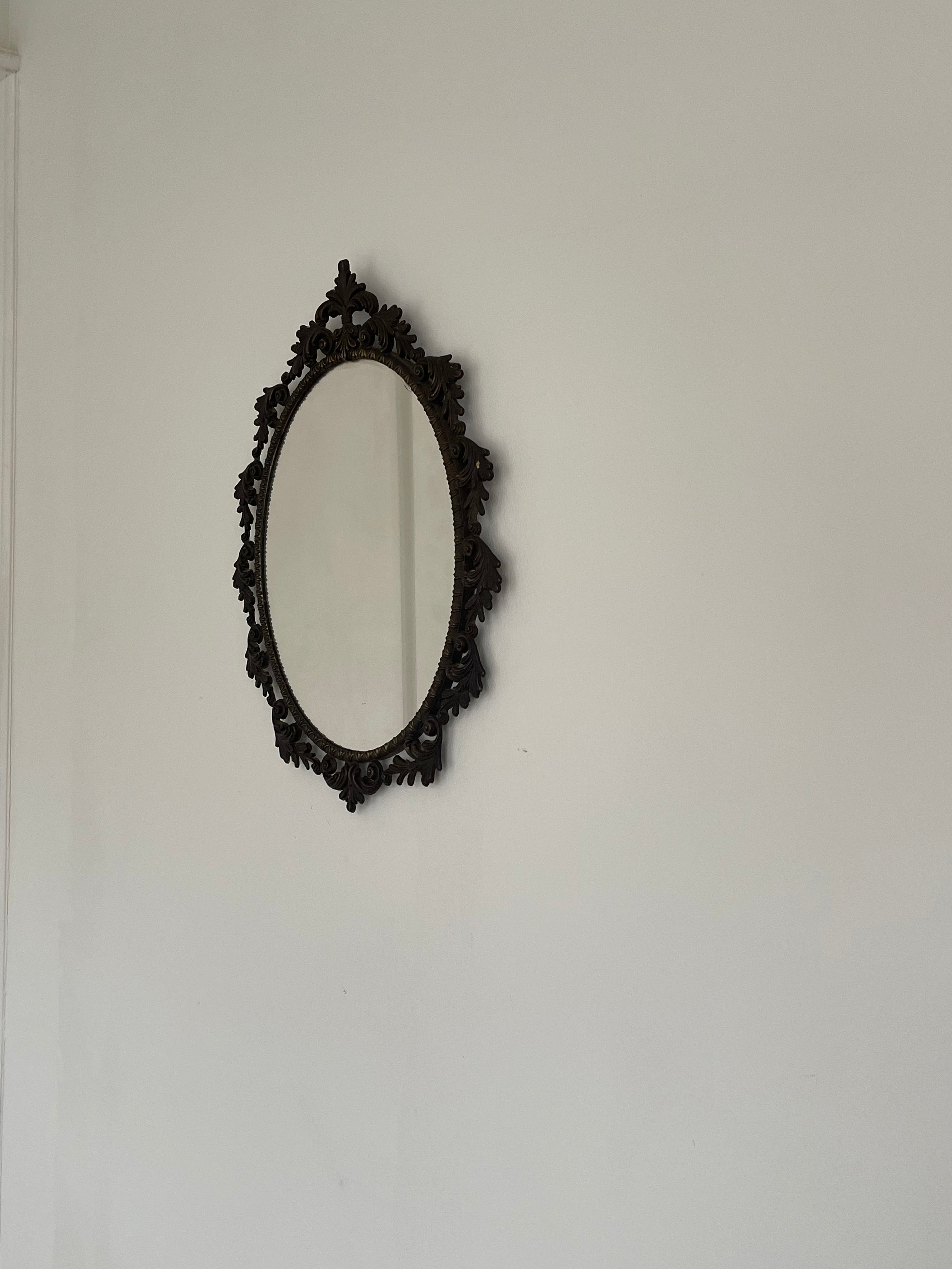 Ornate Vintage Oval Mirror, Rococo Frame — side view against white wall