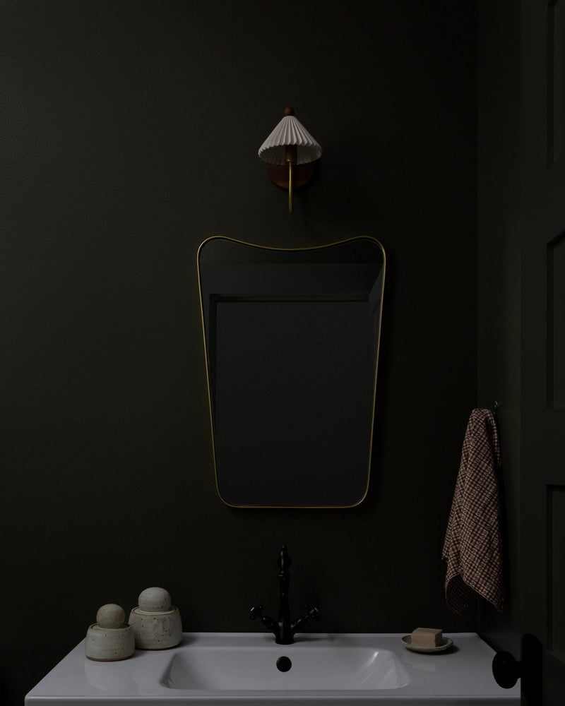 Prairie wall sconce with pleated shade in moody bathroom setting