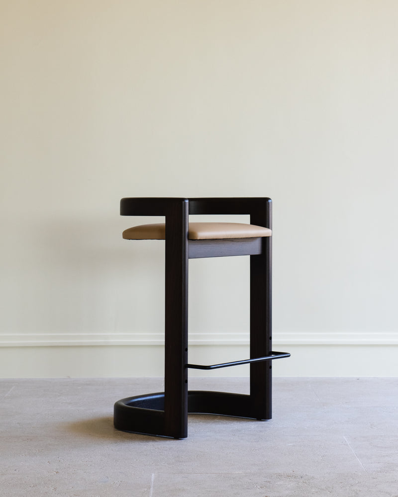 Modern black wood barstool with tan leather seat and footrest