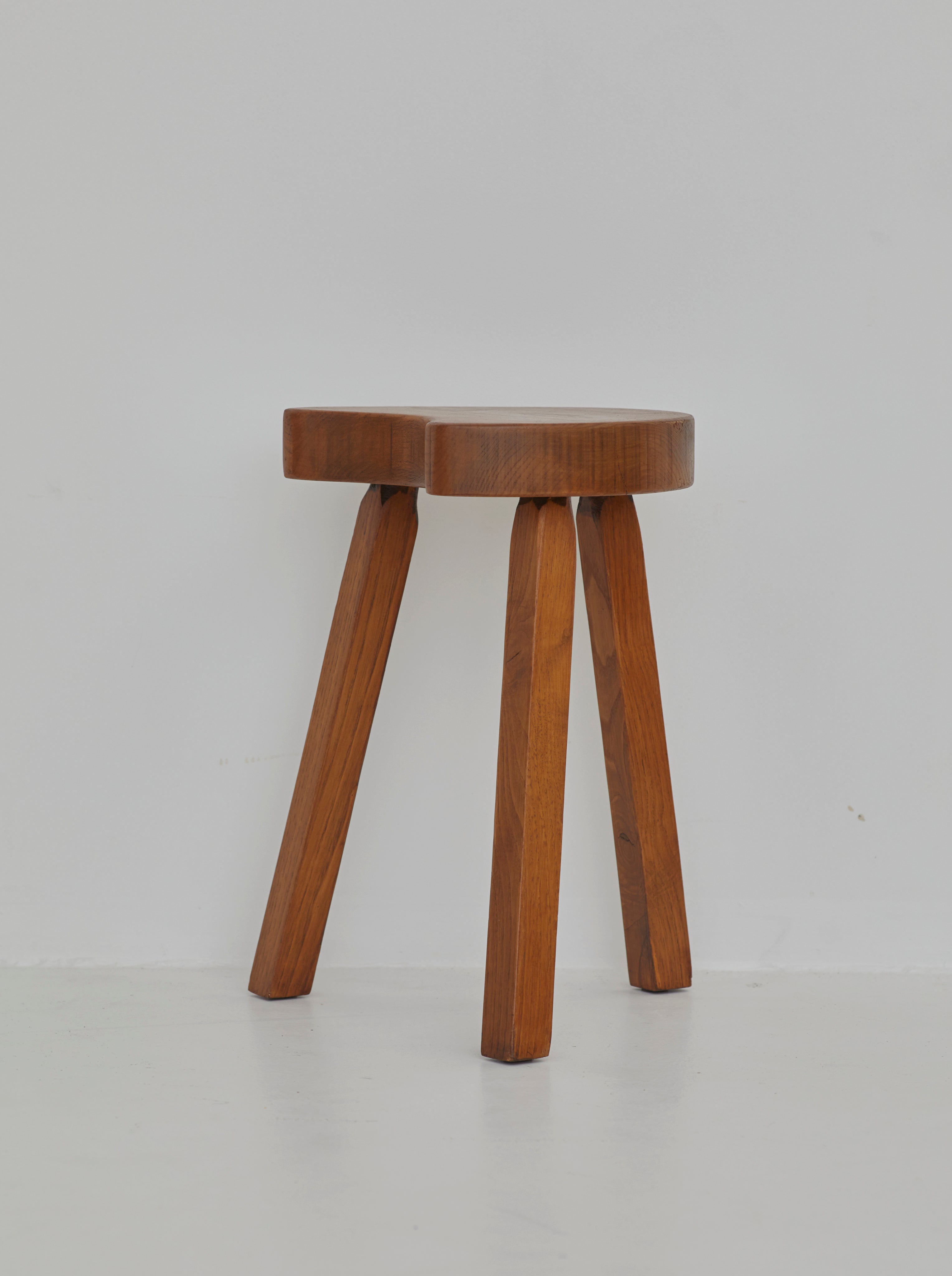 Vintage French handcrafted tripod stool in brutalist style, solid beech wood C. 1960 — side view highlighting tapered wooden