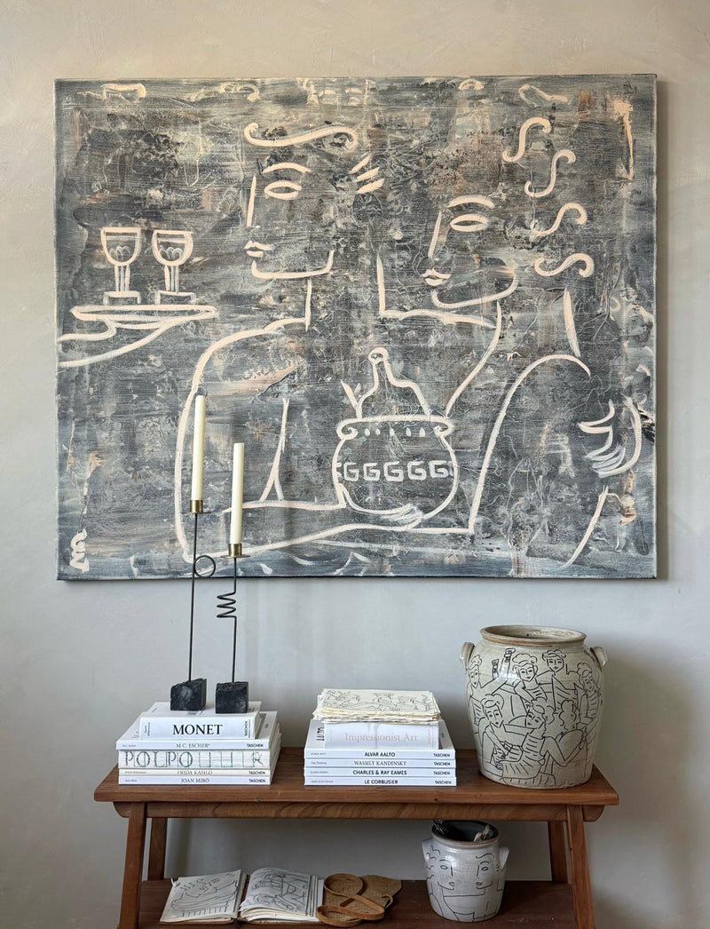Toast to Half Full," a modern line-art painting by Claire de Wolf, in classical abstract style, hangs above a wooden shelf with art books, a ceramic vase, candles, and a cup—all in calming neutral tones.