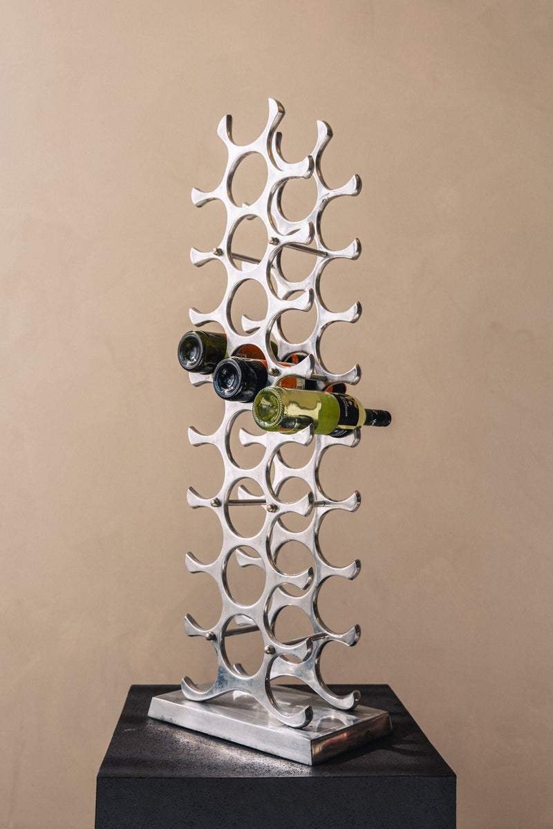 Modern aluminum wine rack with sculptural design holding wine bottles