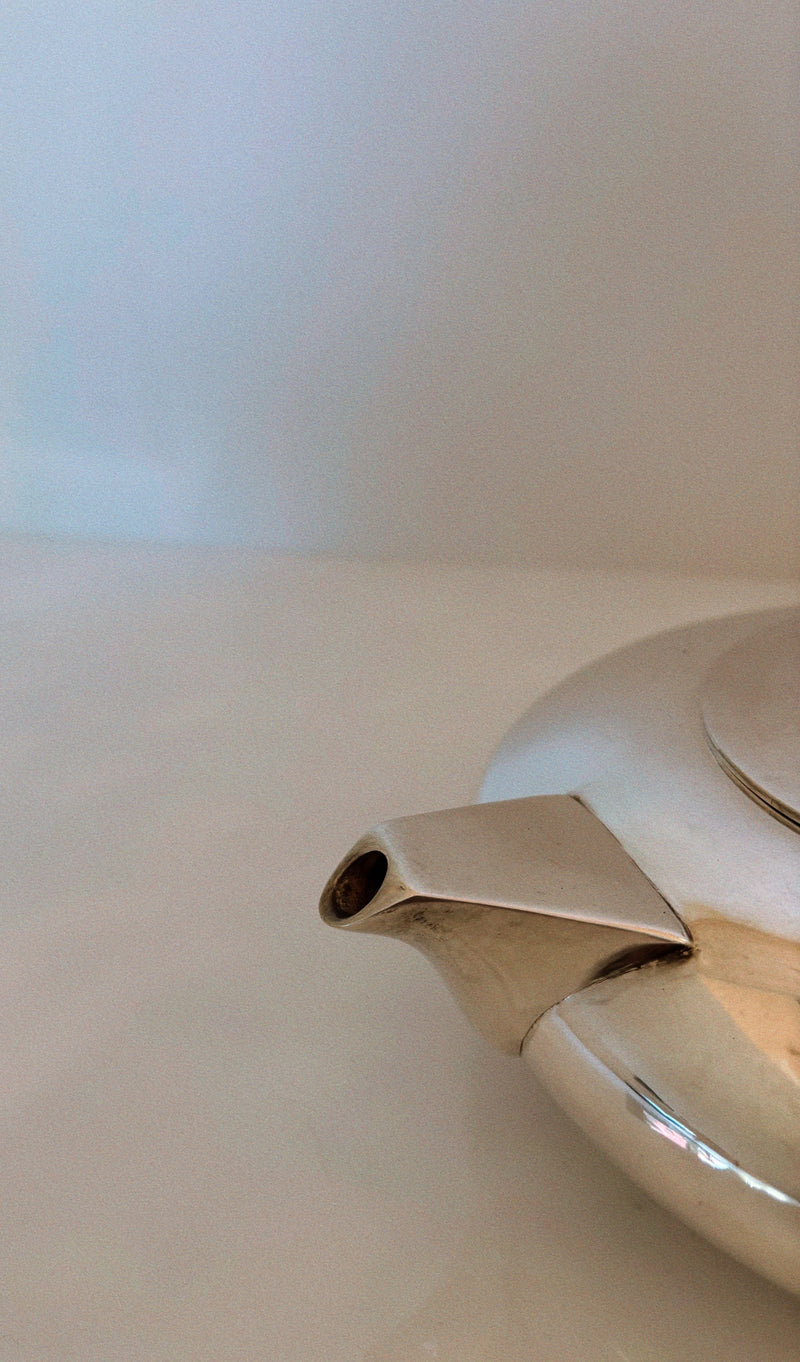 Close-up detail of silver plated teapot spout and handle